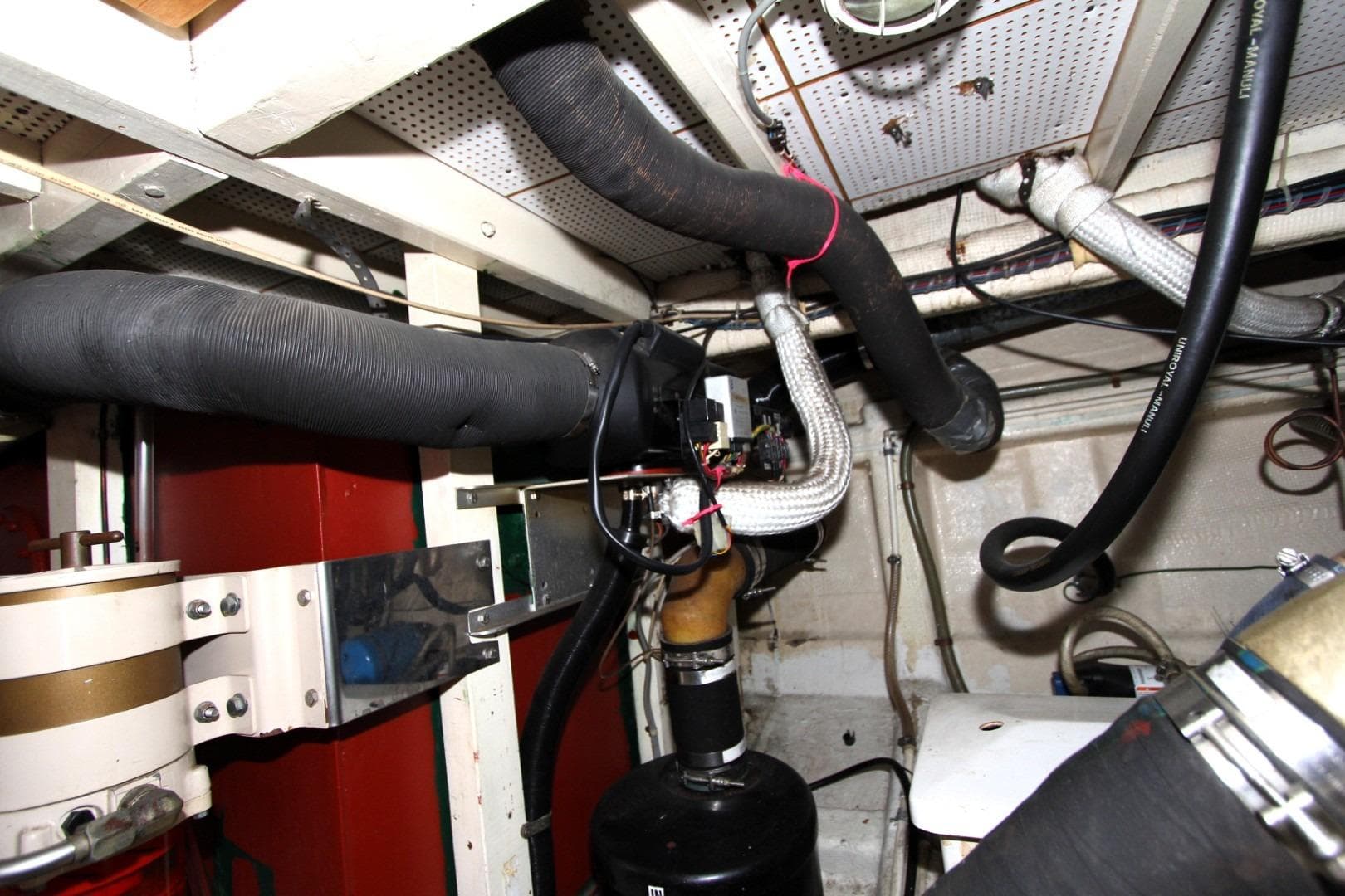 Engine room of 1982 Grand Banks 42 Europa with visible pipes and wiring.