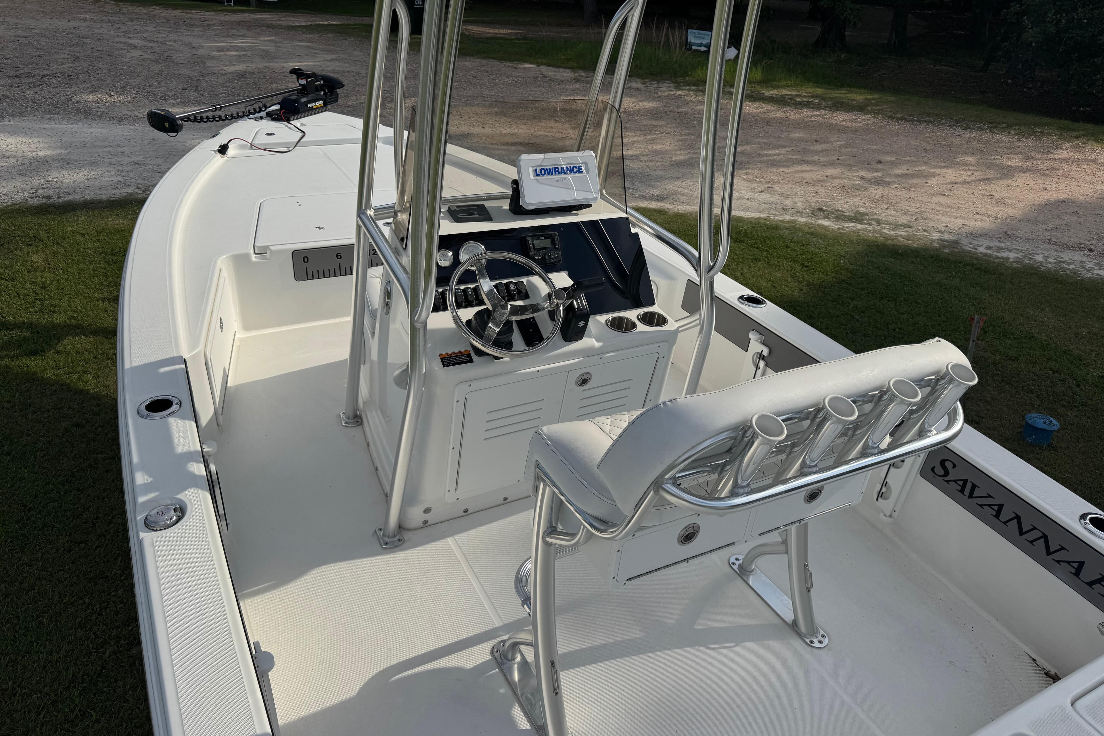 2025 Savannah 220 IS boat interior with steering console and rod holders.