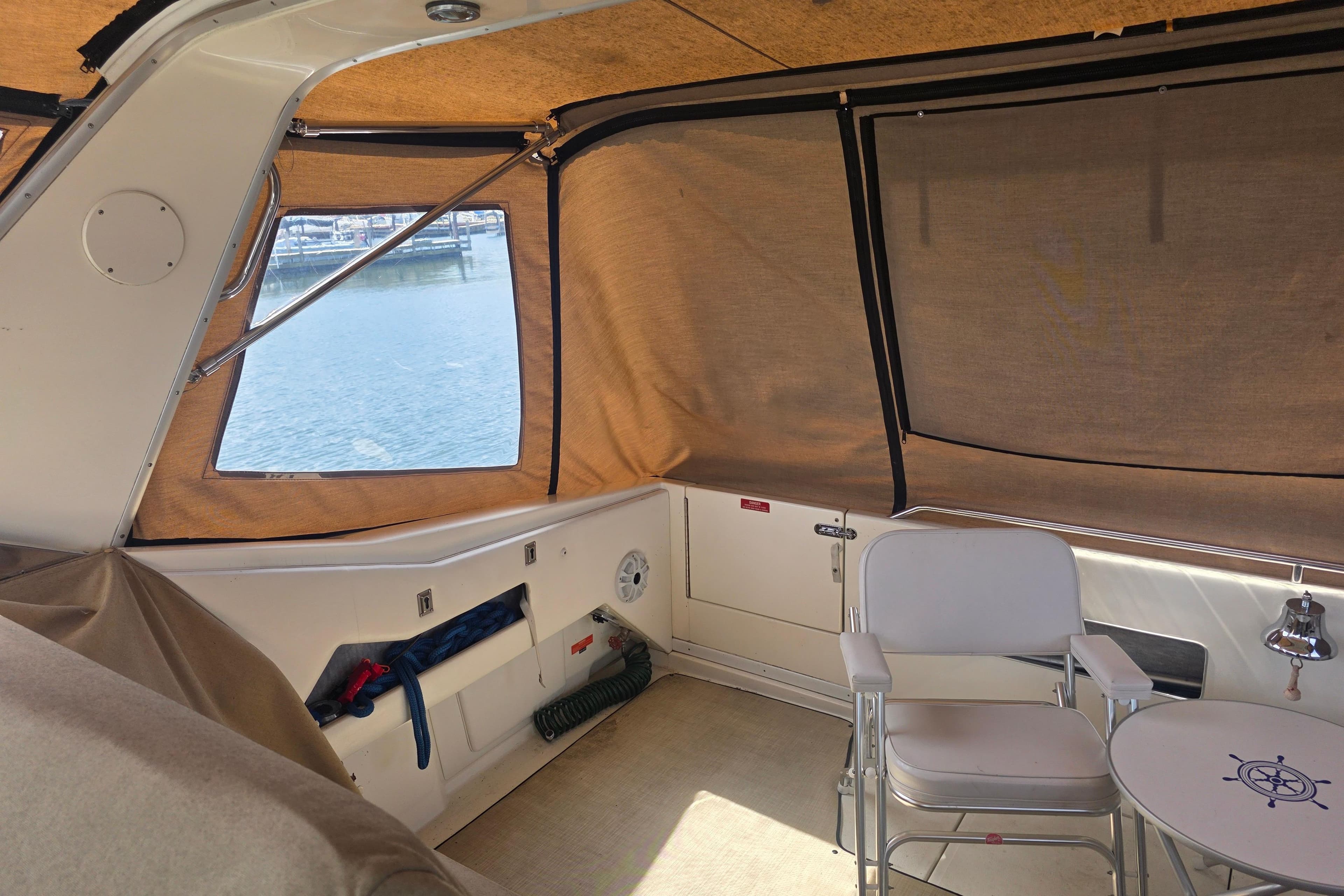 1994 Sea Ray 370 Express Cruiser interior with seating and table, overlooking marina.