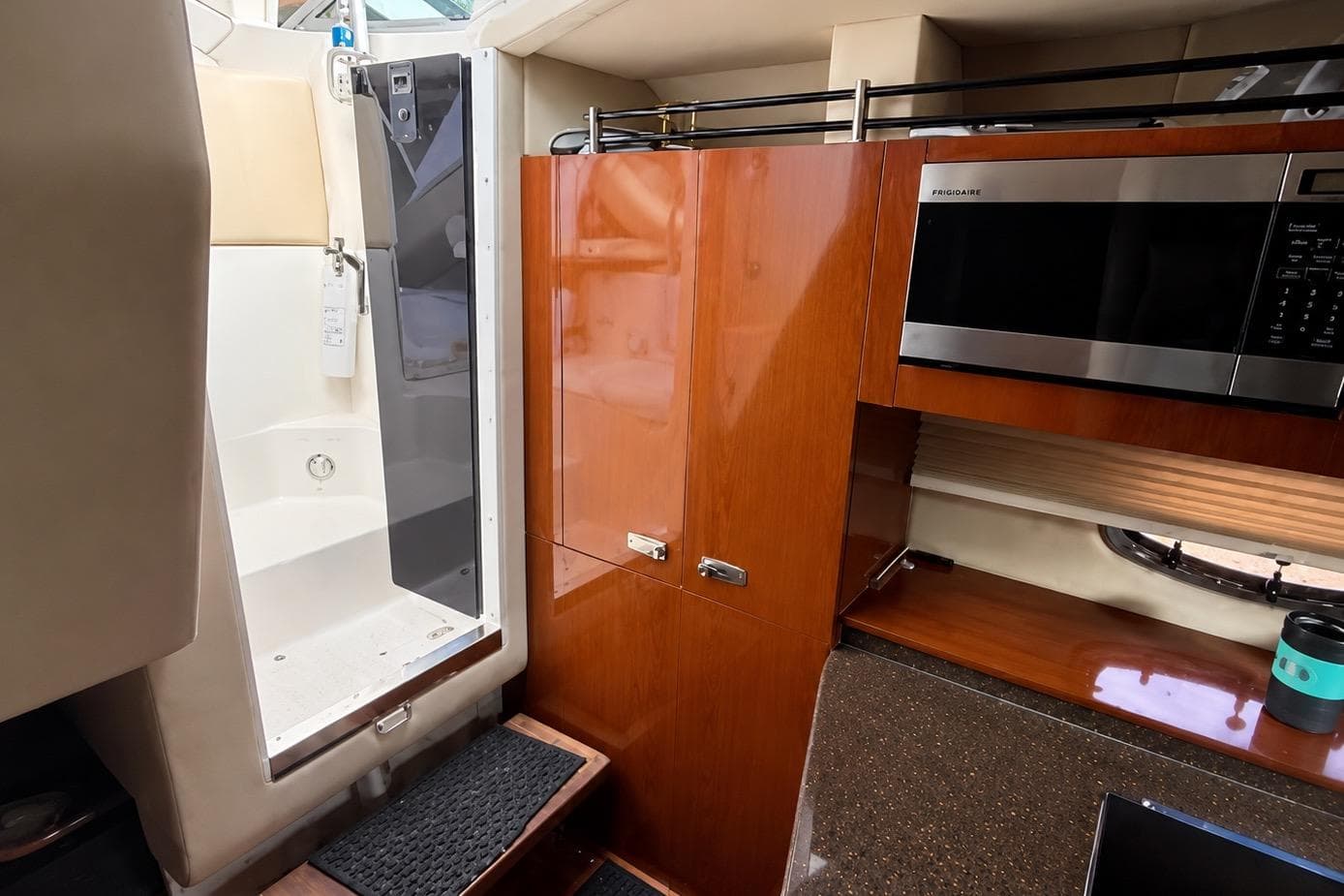 Interior of 2012 Sea Ray Sundancer 310 with shower, wooden cabinets, and microwave.