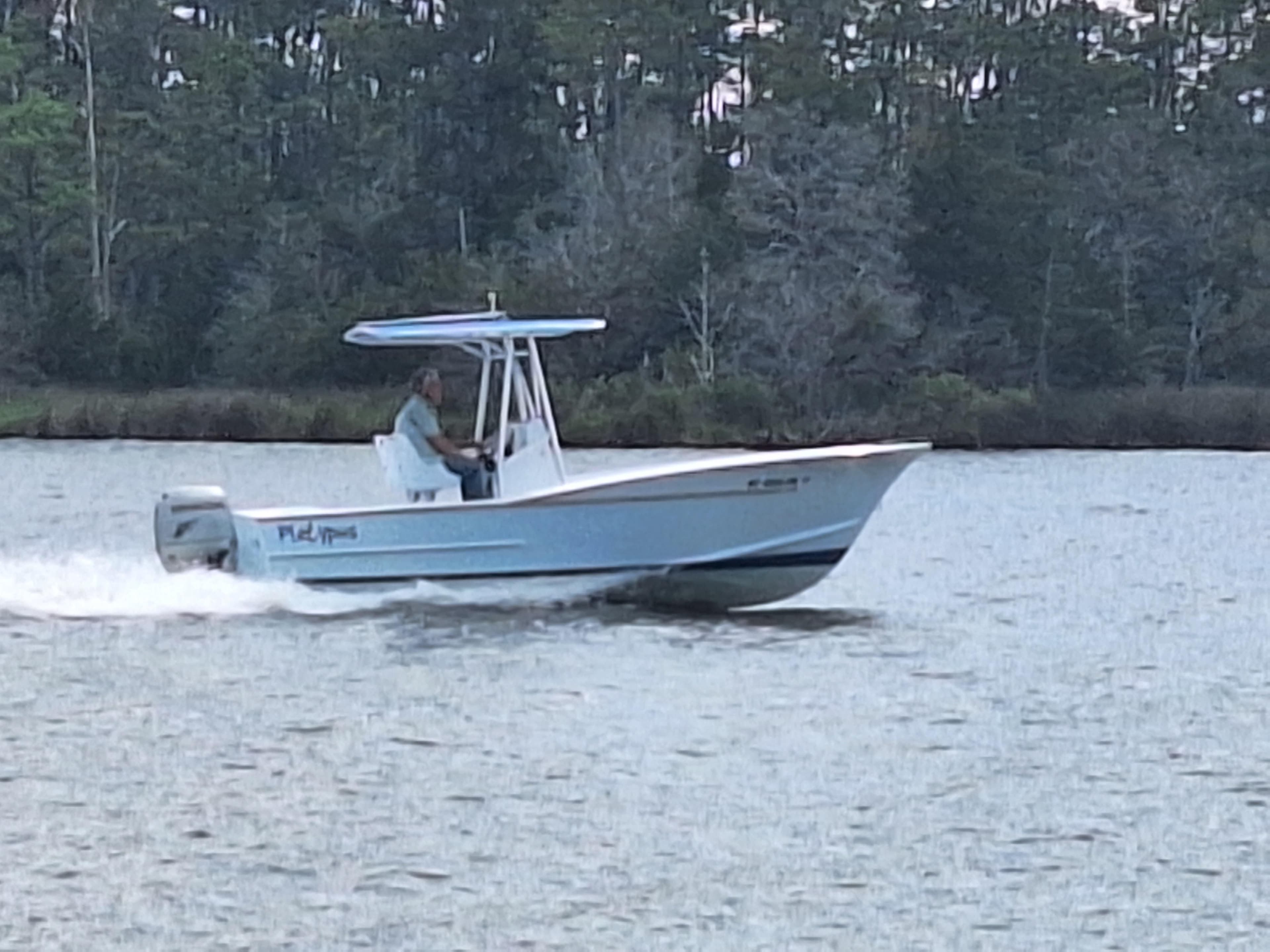 2008 Custom Carolina boat cruising on a calm river.
