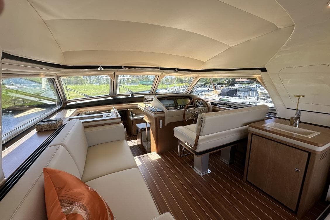 Luxurious interior of 2026 Linssen Grand Sturdy 550 Variotop yacht with elegant seating and helm.