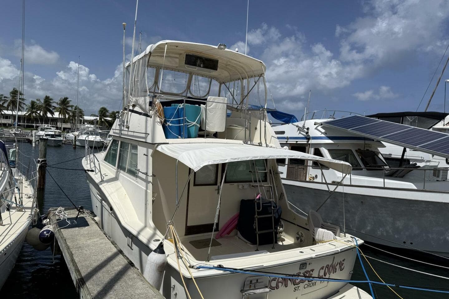 1979 Hatteras 37 Convertible yacht docked at marina under clear skies.