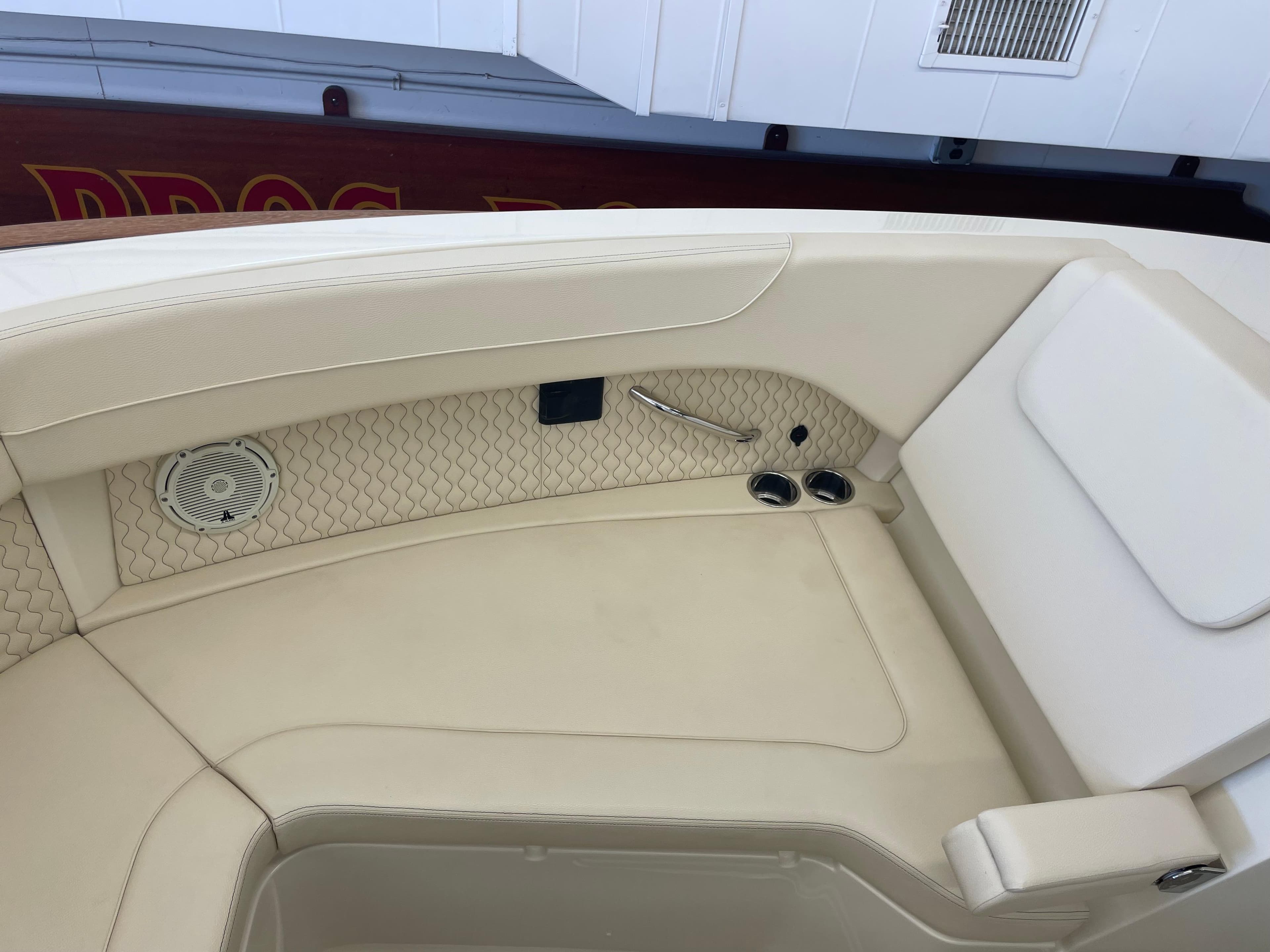 2024 Chris-Craft Calypso 32 boat interior with beige seating and speaker detail.
