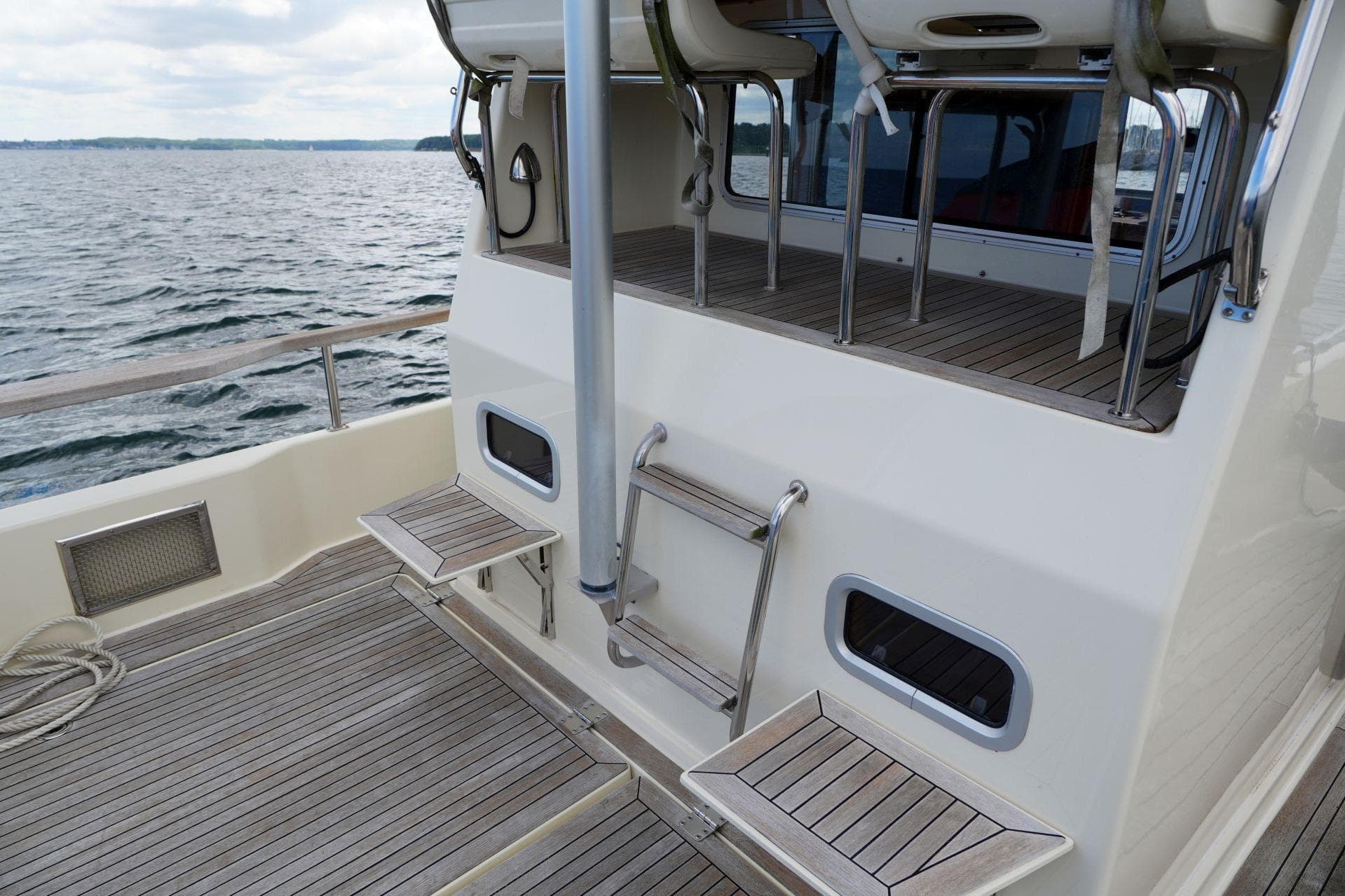 2011 Botnia Targa 27.1 boat deck with wooden flooring and seating.