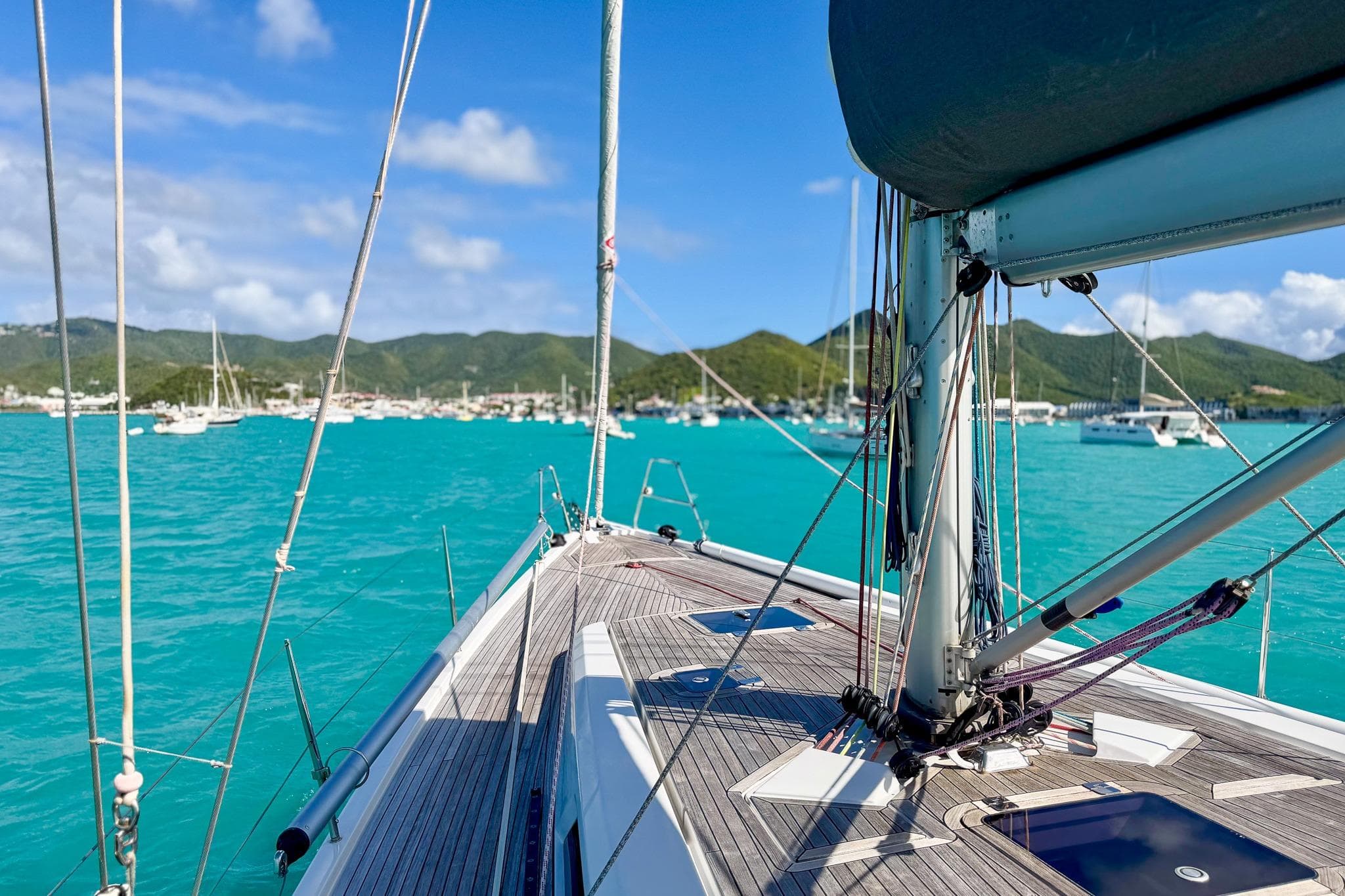 Sailing on a 2010 Grand Soleil 46 yacht in turquoise waters, scenic coastal view.