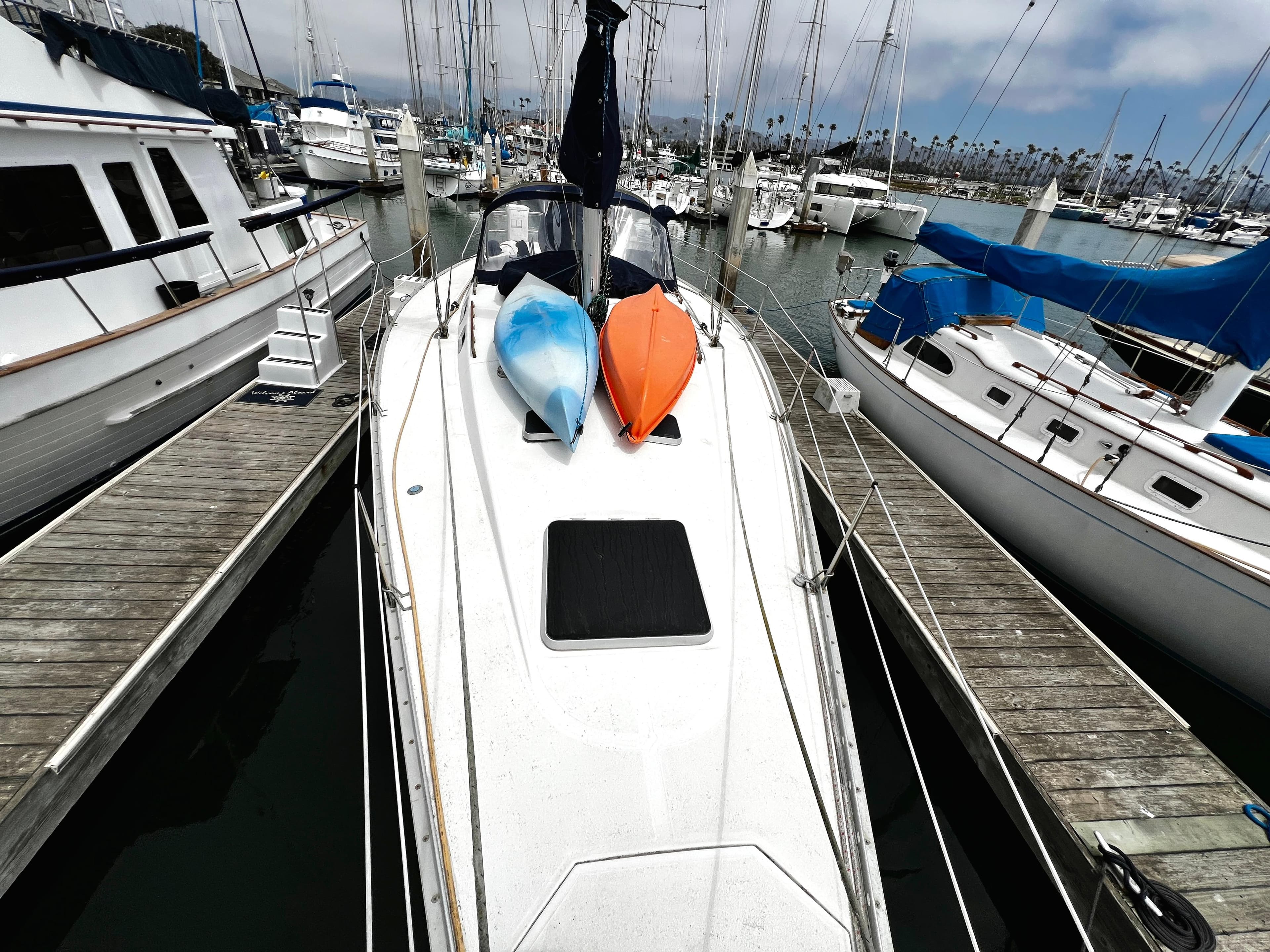 Sailboat docked with kayaks on deck, Hunter 40 model, 1988, in a marina setting.