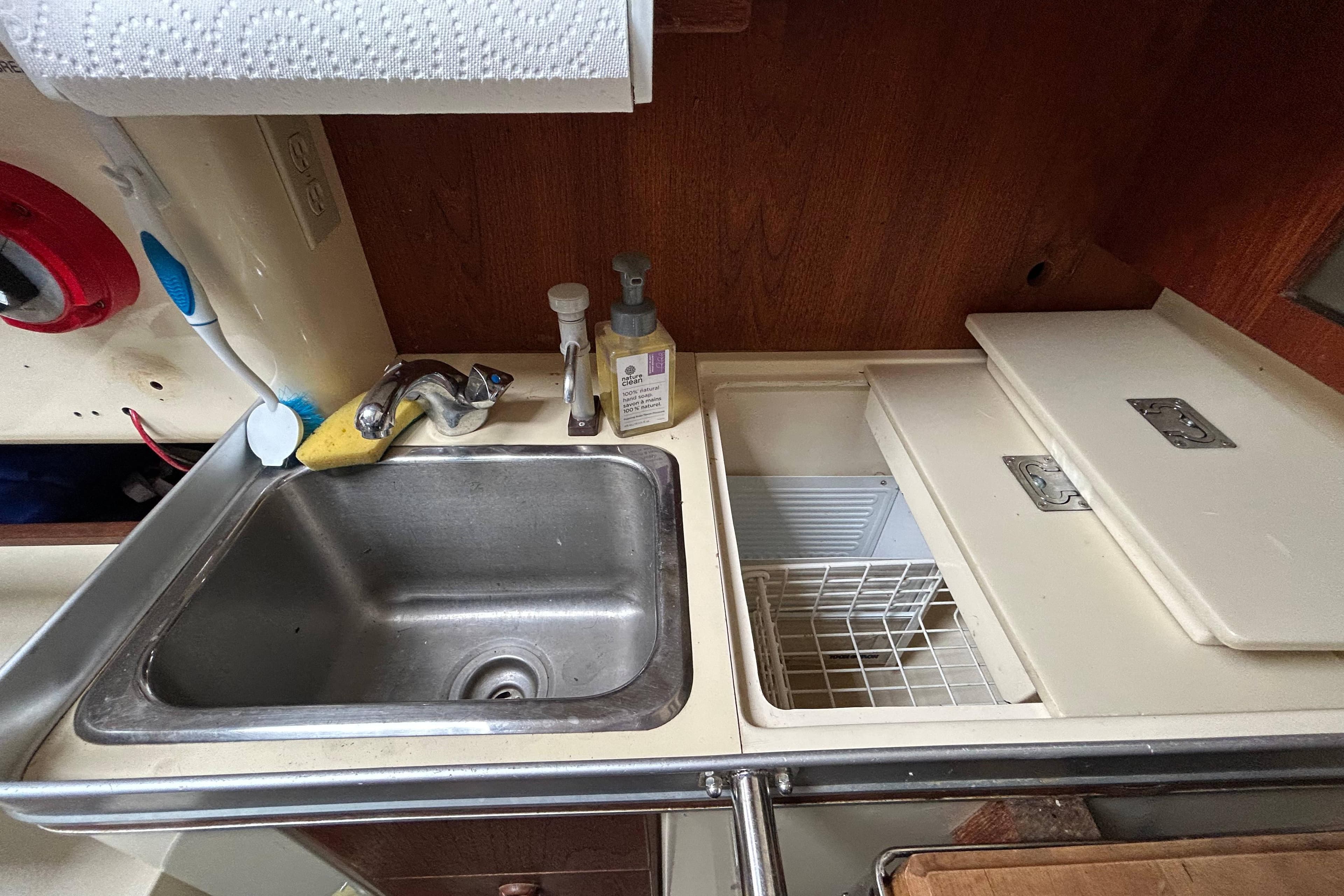 Compact kitchen sink and counter area in a 1985 CS 30 model boat.