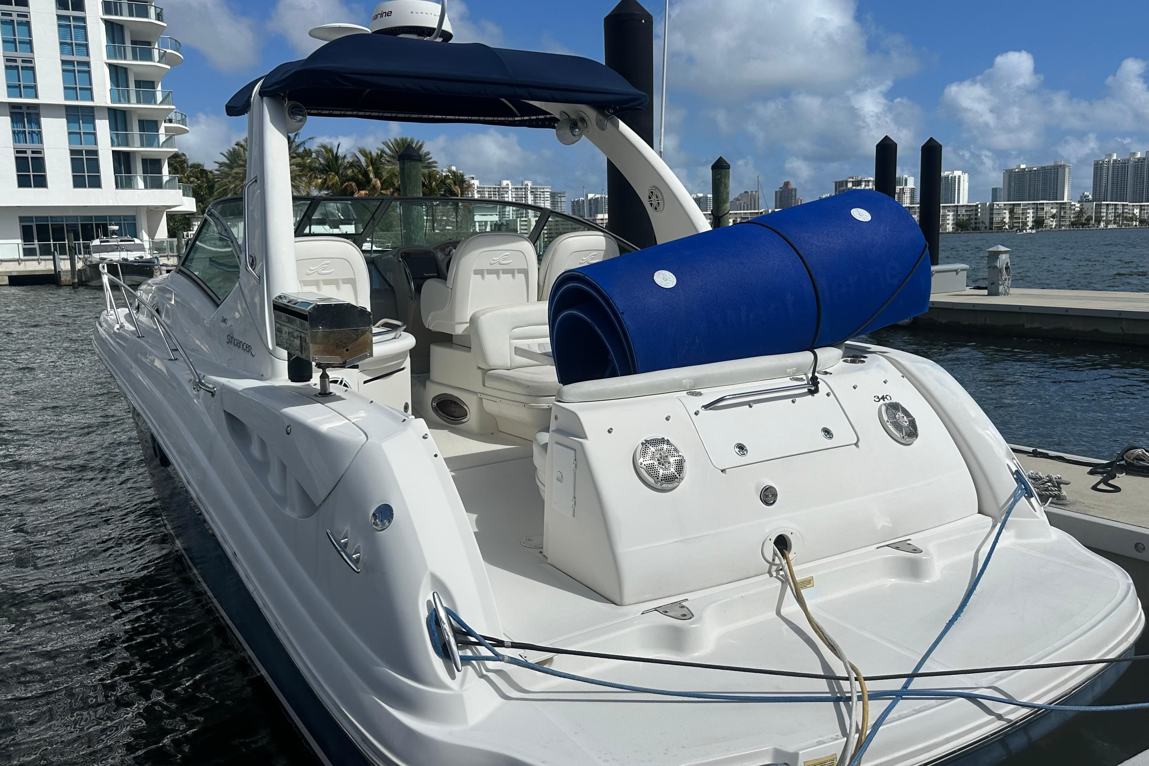 2008 Sea Ray 340 Sundancer docked at marina, featuring spacious seating and blue accessories.