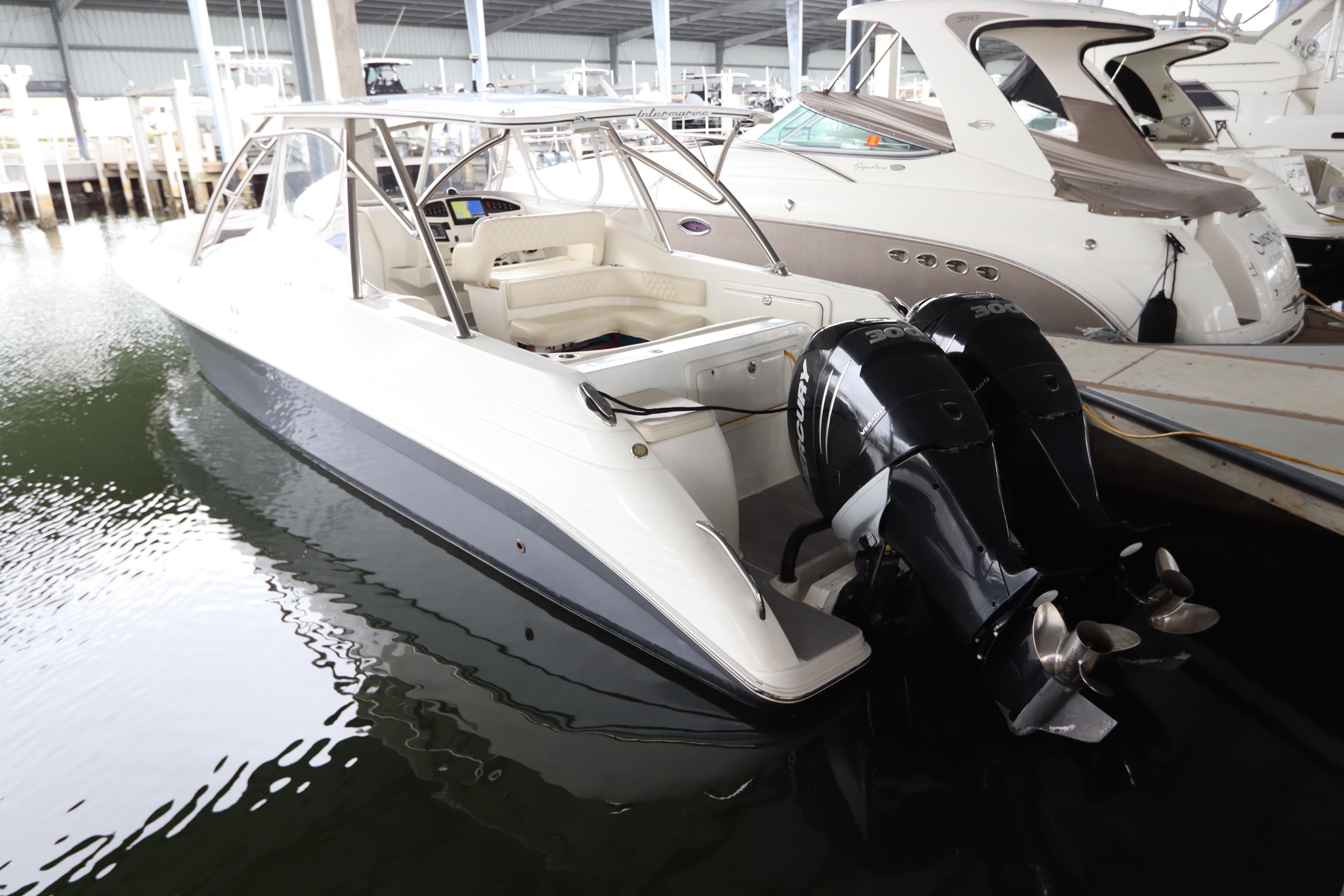 2014 Intermarine 380 Sport boat with dual outboard engines docked in marina.
