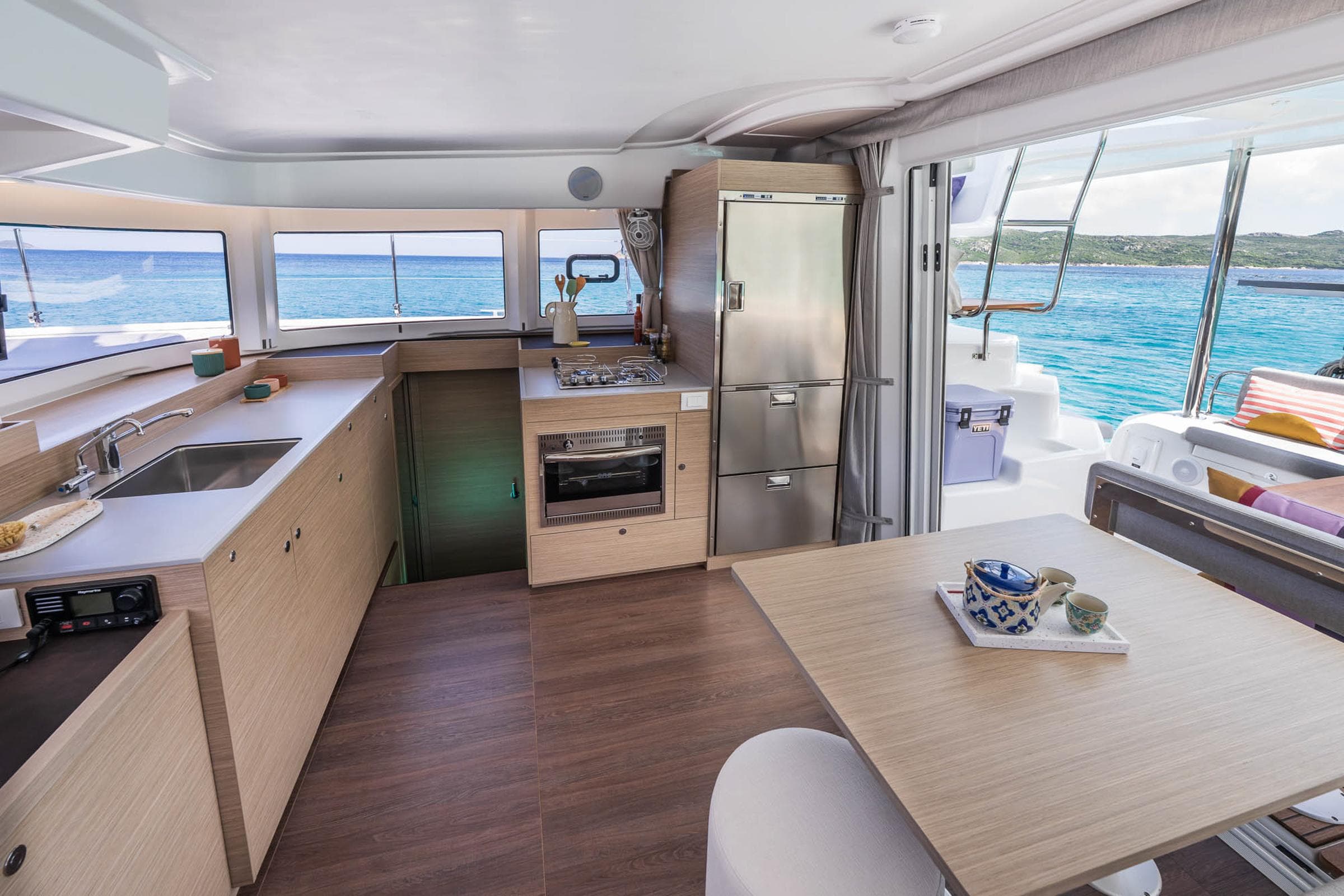 Modern kitchen interior of 2025 Lagoon 38 yacht with ocean view.