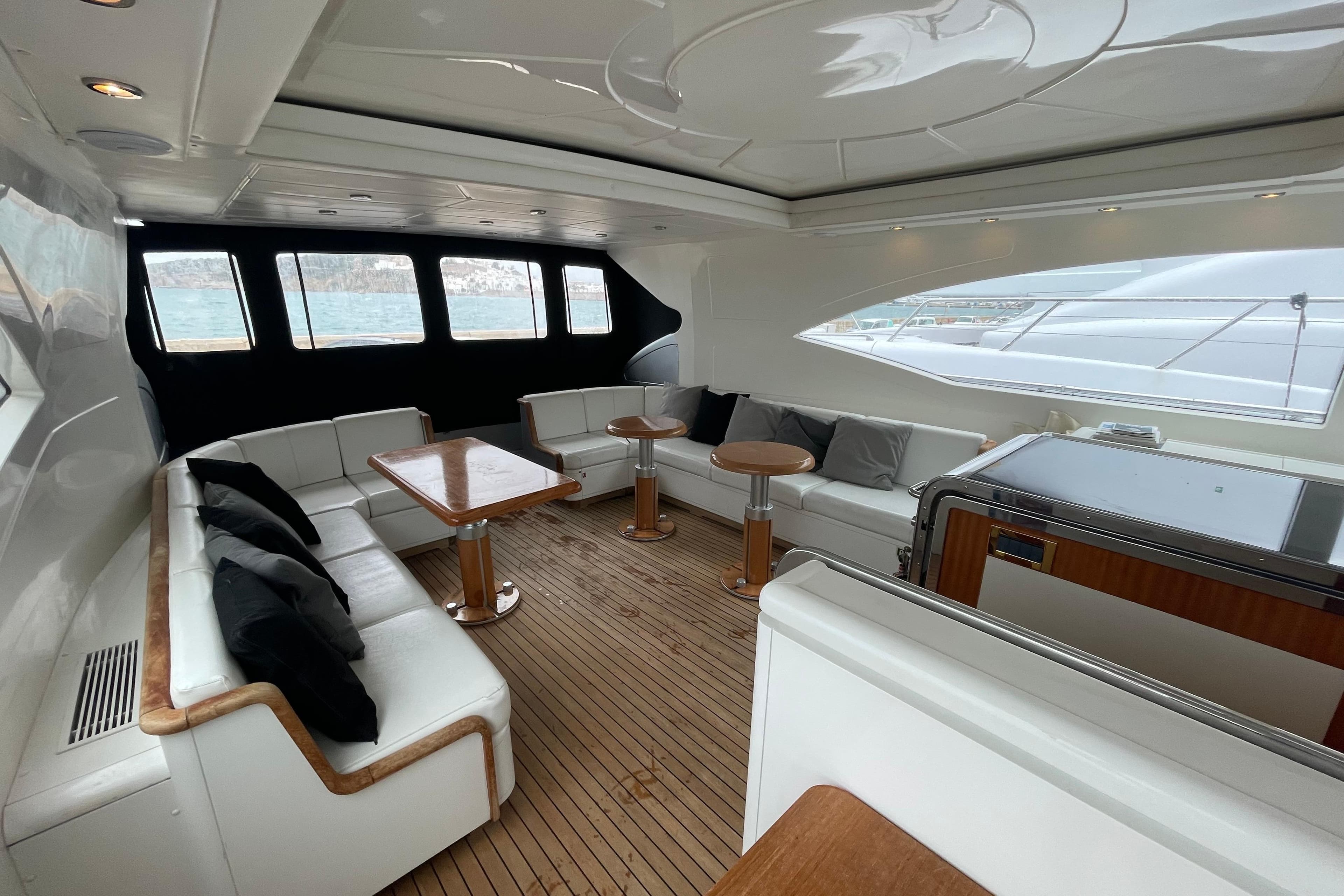 Luxurious interior of 1999 Mangusta 72 yacht with elegant seating and wooden flooring.