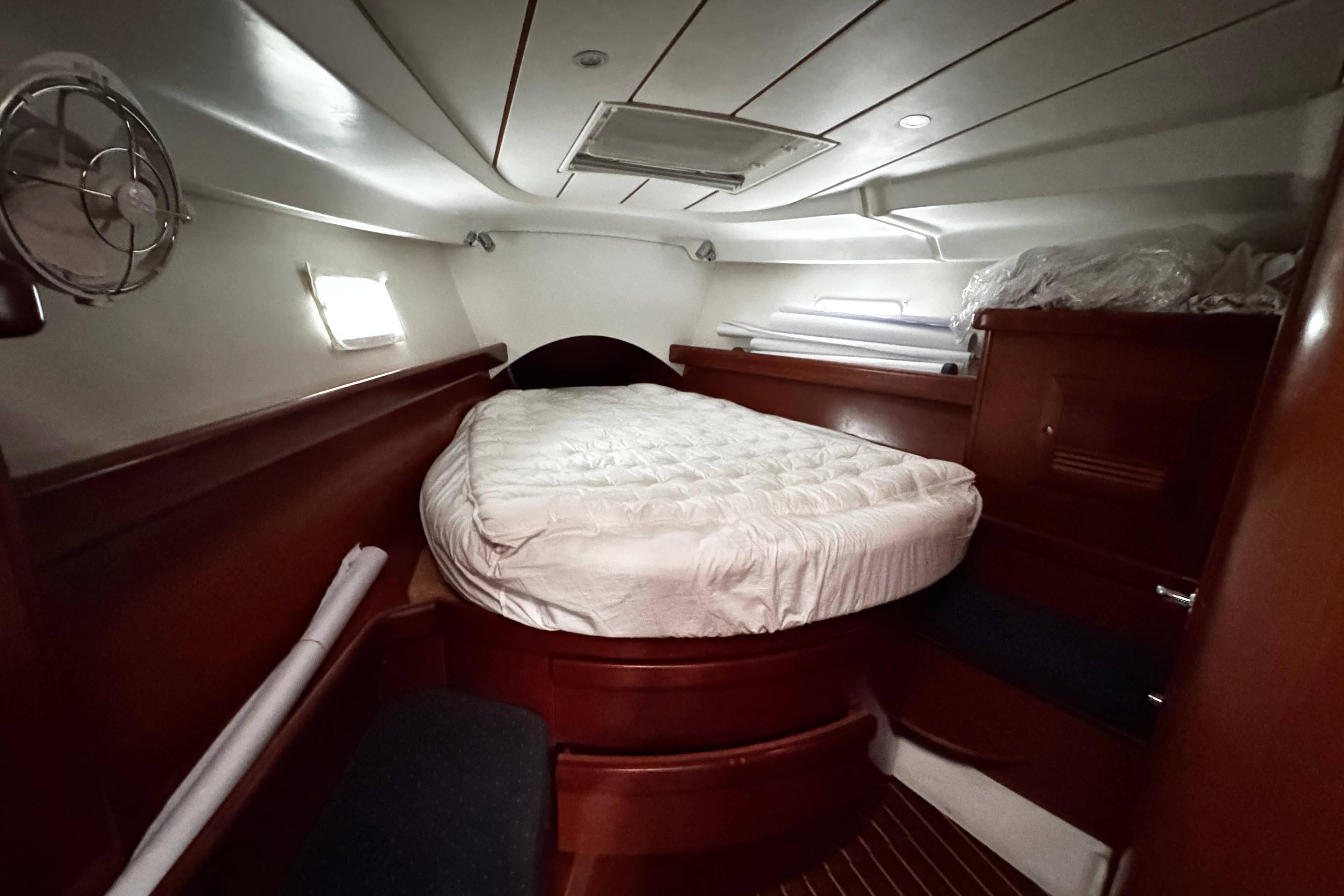 Cozy cabin interior of 2007 Beneteau 423 sailboat with bed and wooden furnishings.