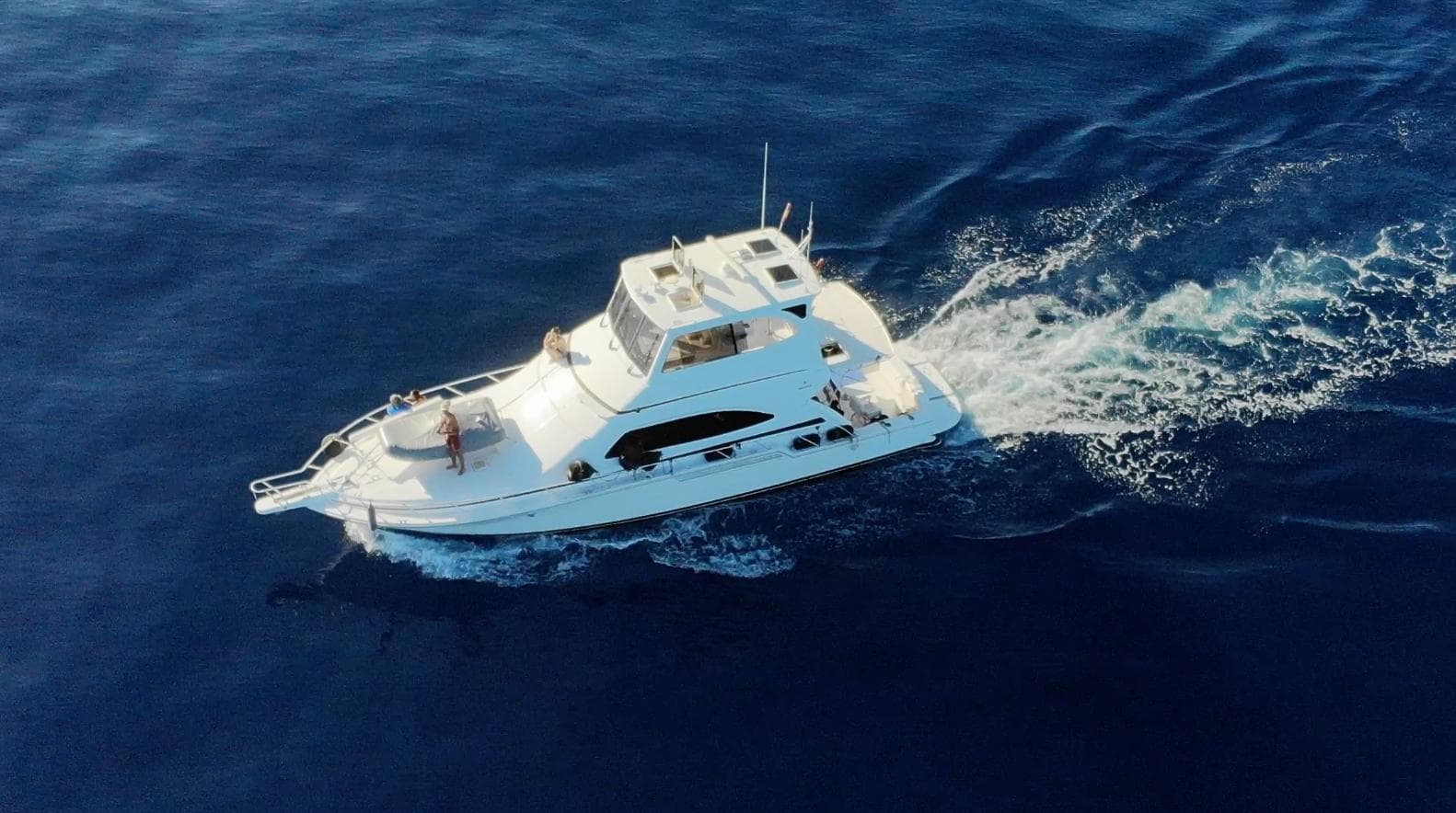2004 Bertram 510 yacht cruising on open blue sea, aerial view.