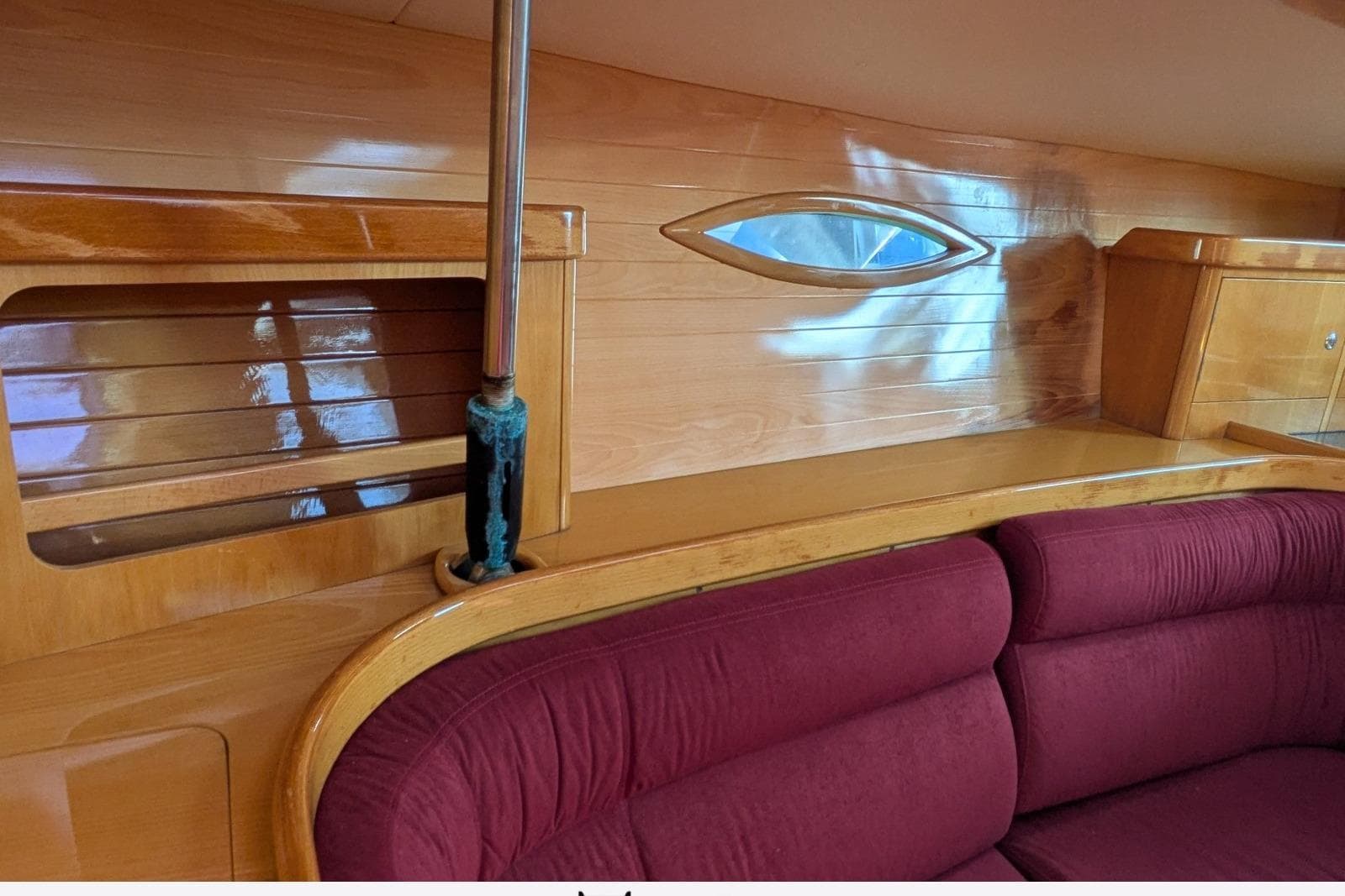 Interior of a 2004 Feeling 44 DI yacht with wooden paneling and red seating.