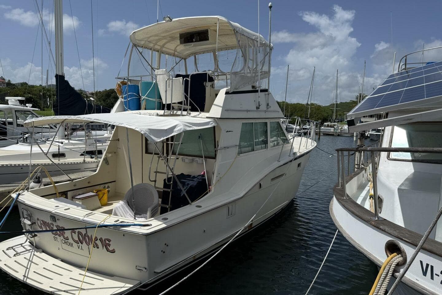 1979 Hatteras 37 Convertible yacht docked in a marina under a clear blue sky.