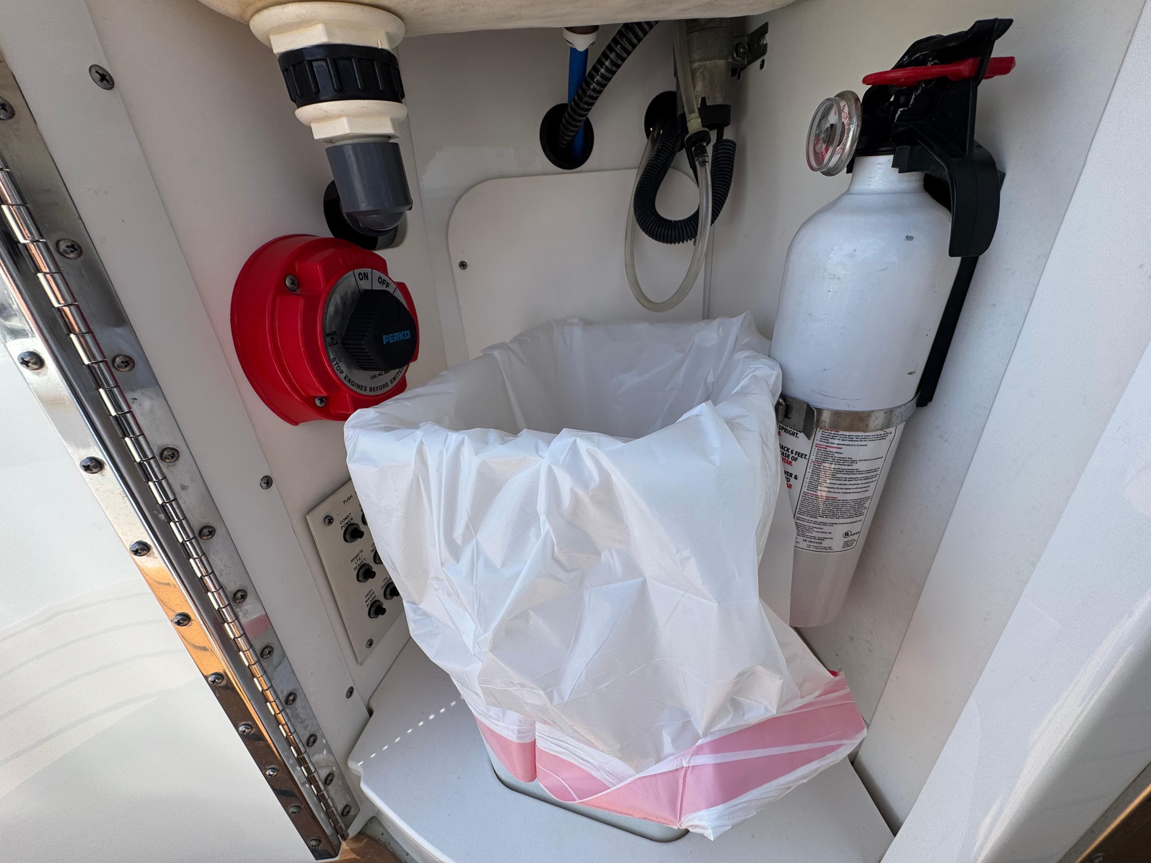 Fire extinguisher and waste bin in 2008 Formula 40 PC boat compartment.