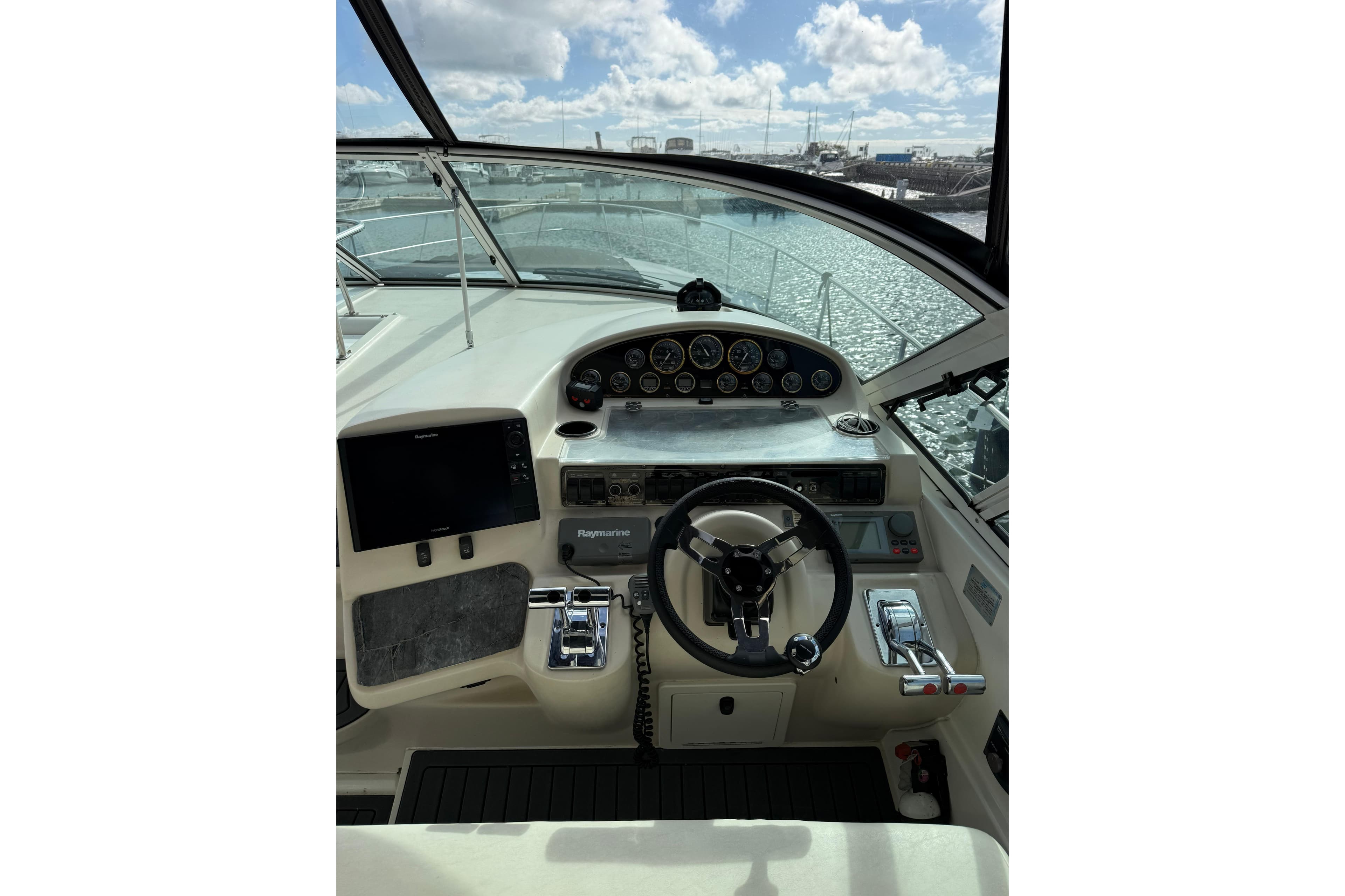 2001 Cruisers Yachts 3870 Express helm with steering wheel and navigation controls.