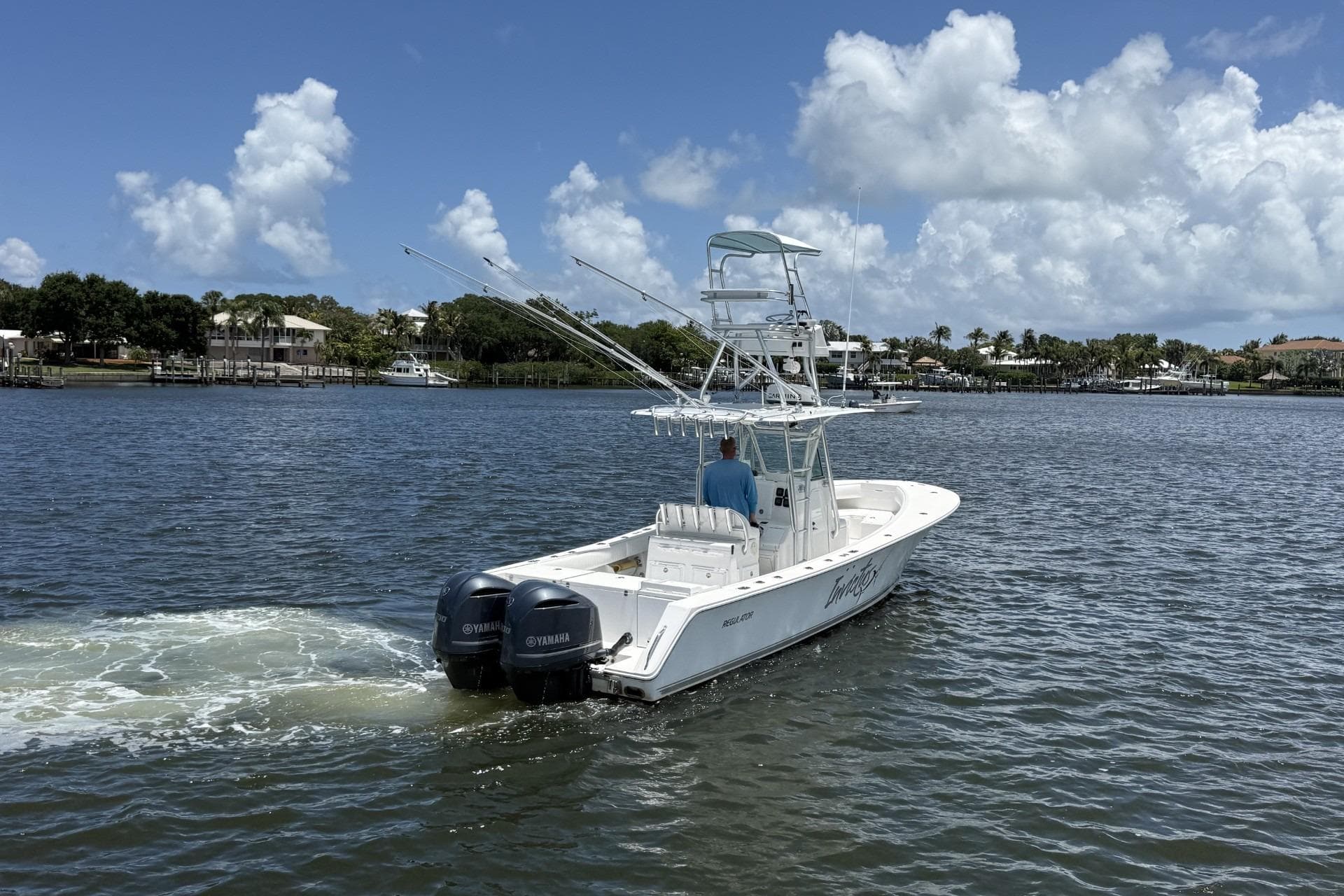 2006 Regulator 32 Center Console boat cruising on a sunny day with dual Yamaha engines.
