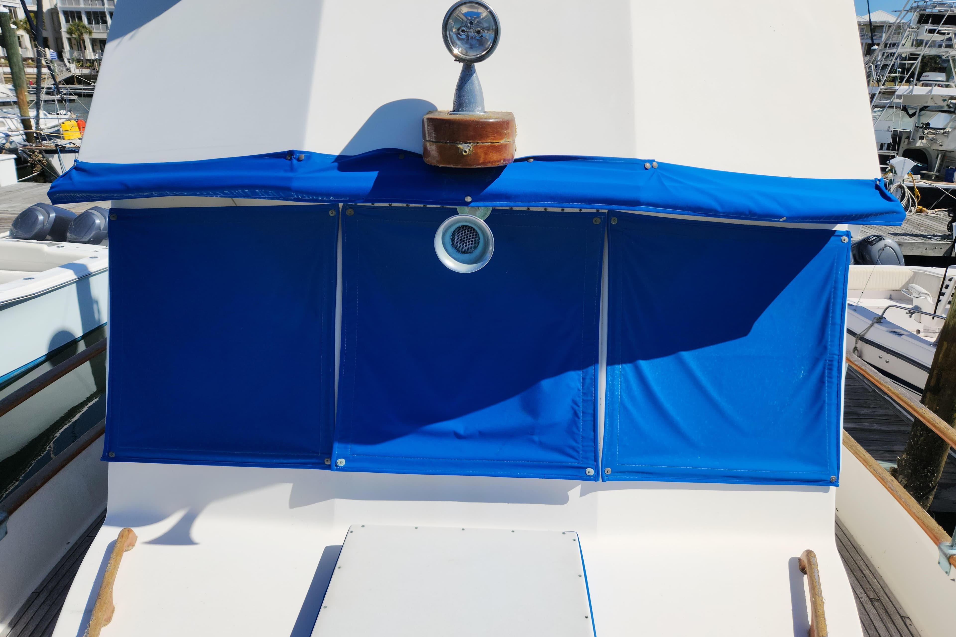 1983 Grand Banks 36 Classic yacht with blue canvas cover in marina.