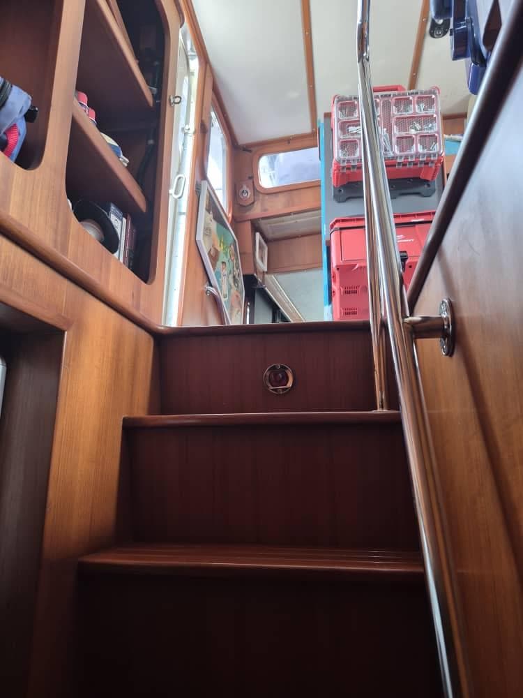 Interior stairs of a 1994 Nordhavn 46 yacht with wooden finish.