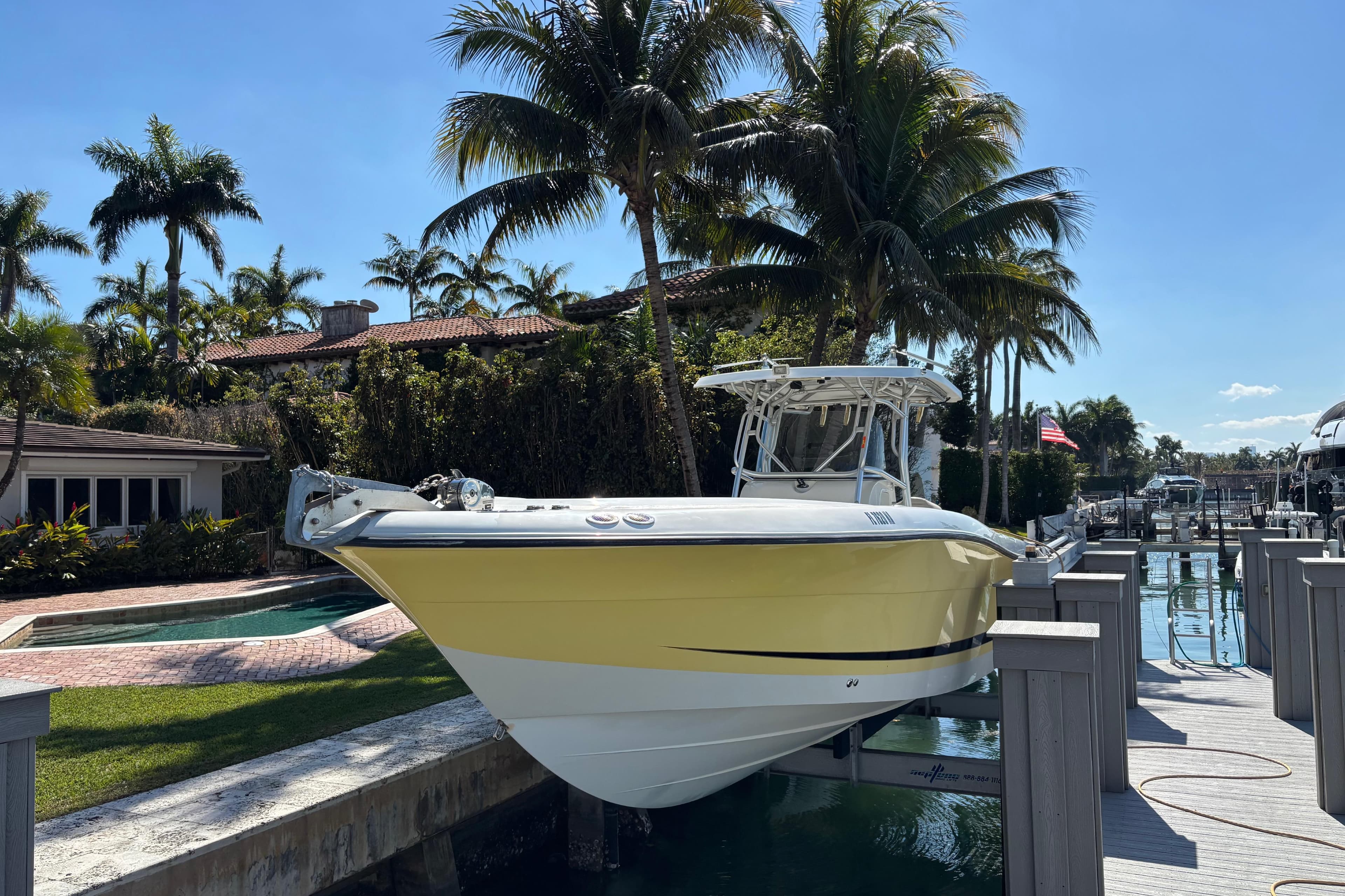 2006 Hydra-Sports Vector 3300 CC boat docked near tropical palm trees.
