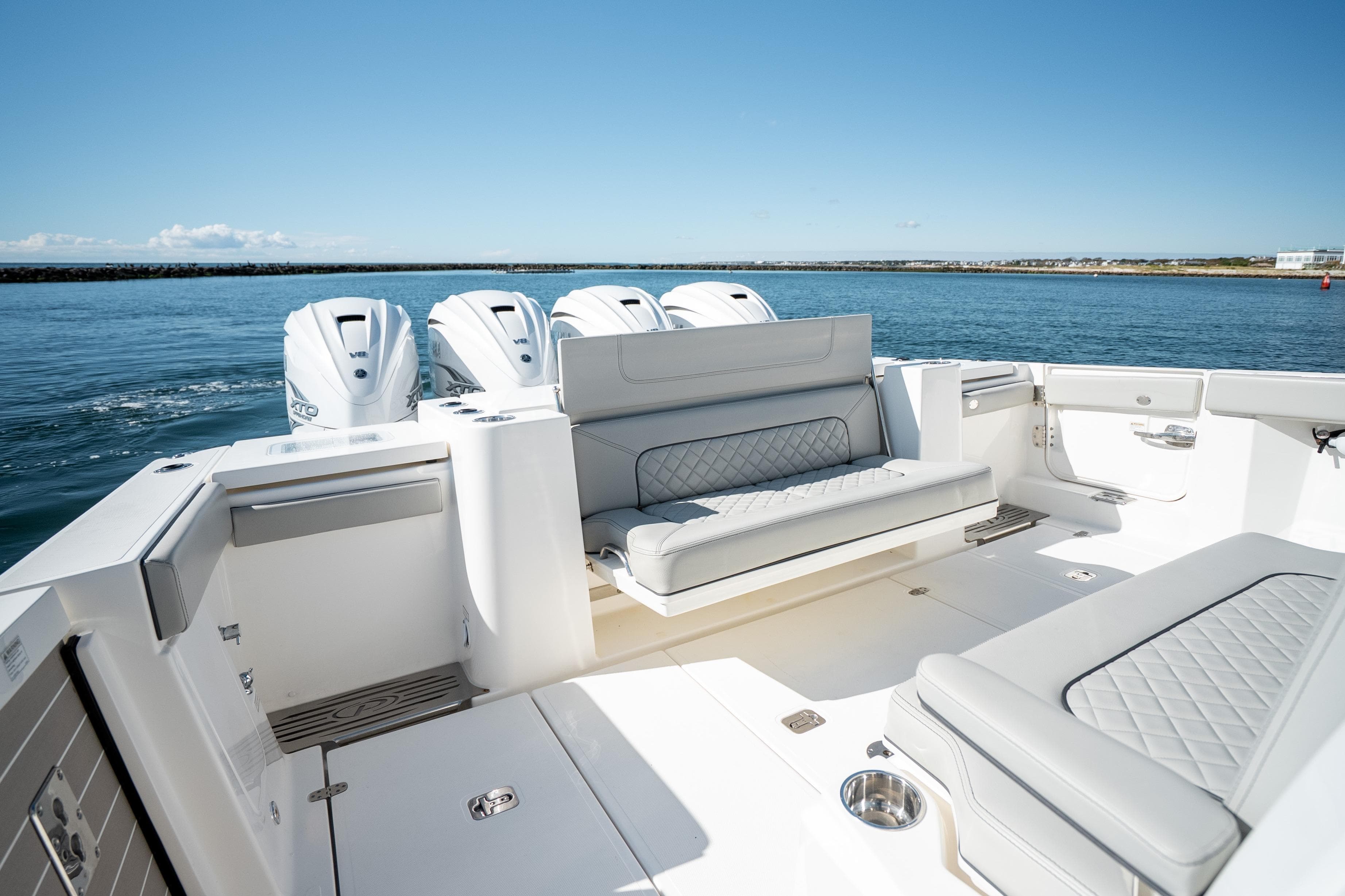 2023 Pursuit S 428 Sport boat interior with seating and quad outboard engines.