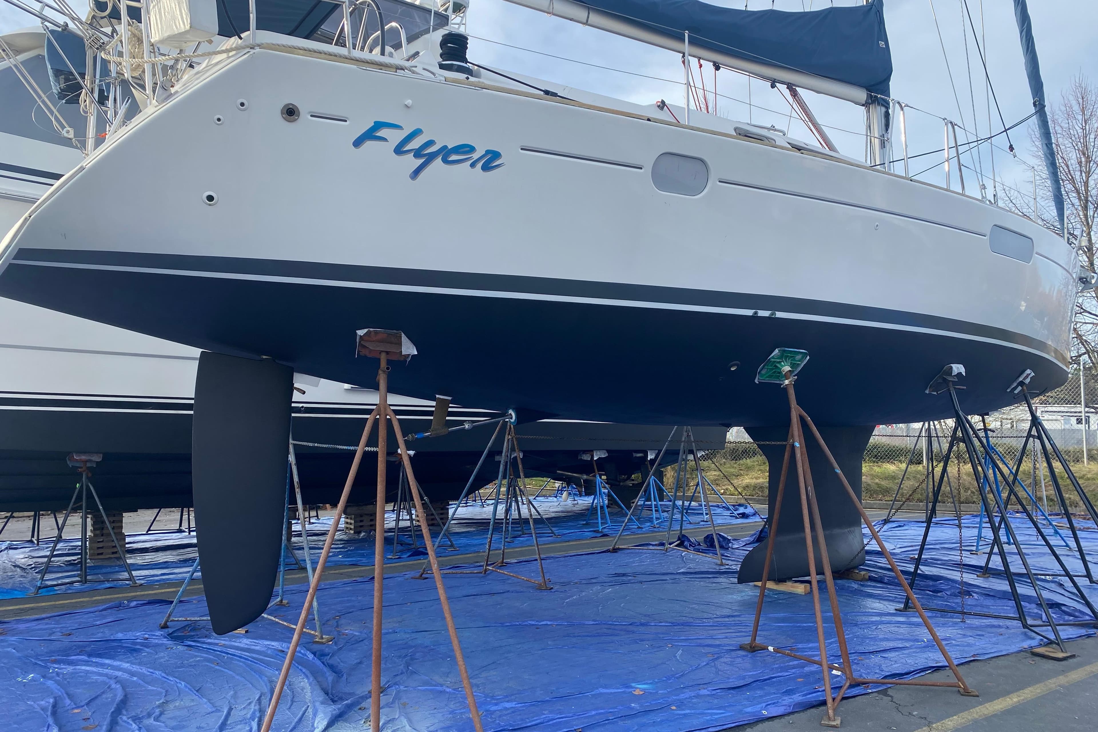 2010 Jeanneau Sun Odyssey 44i sailboat on stands, named "Flyer," in a boatyard.