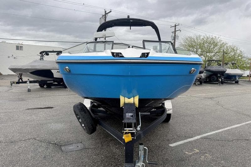 2021 Yamaha Boats 212X in blue on trailer, parked outdoors.