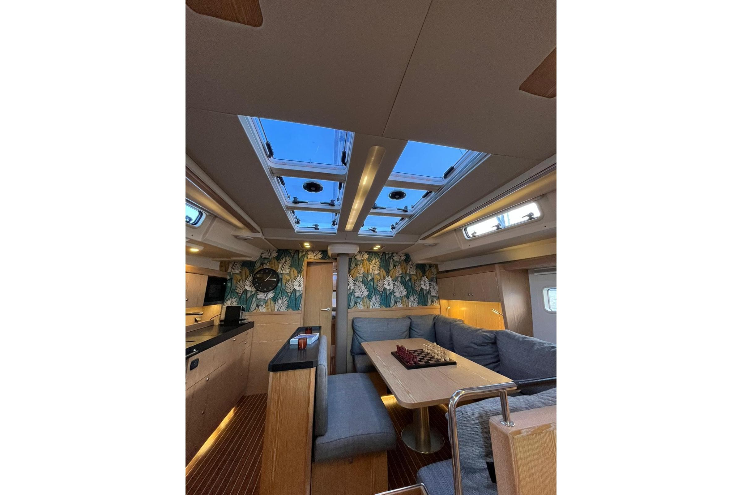 Luxurious interior of 2015 Hanse 575 yacht with skylights and modern decor.