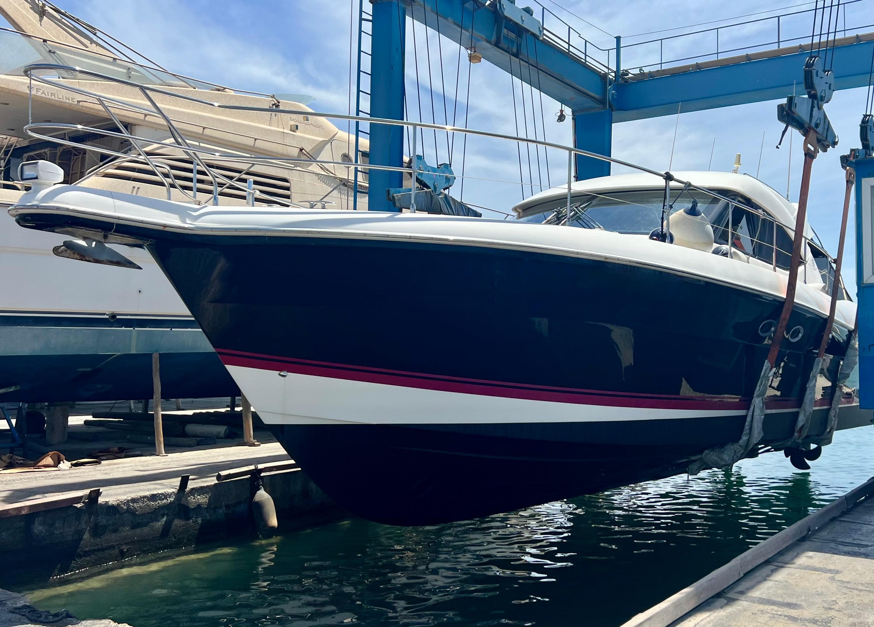2008 Riviera 4700 Sport Yacht in dry dock, suspended for maintenance.