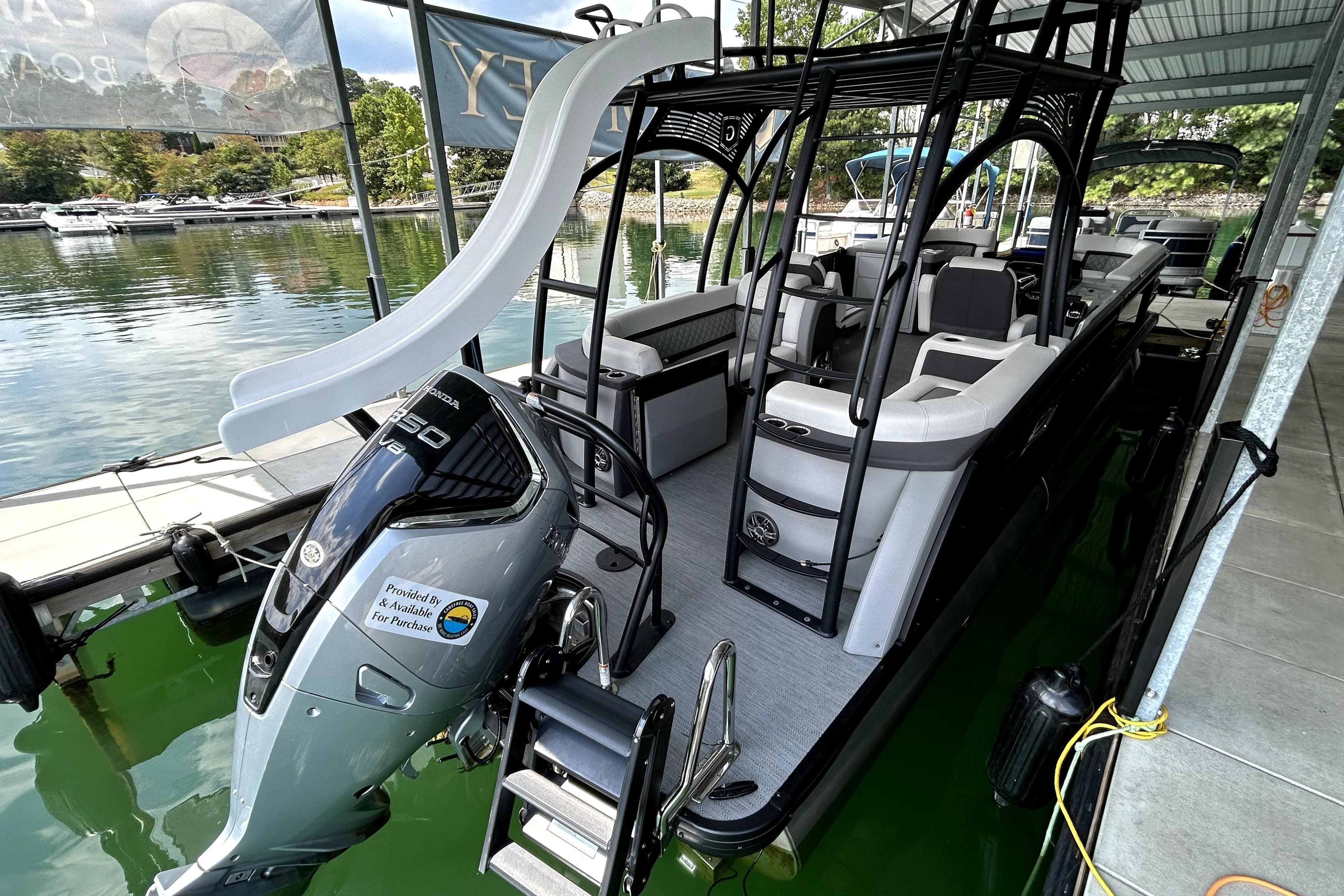2025 Godfrey AquaPatio 255 SDC Slide pontoon boat with slide and Honda outboard motor.