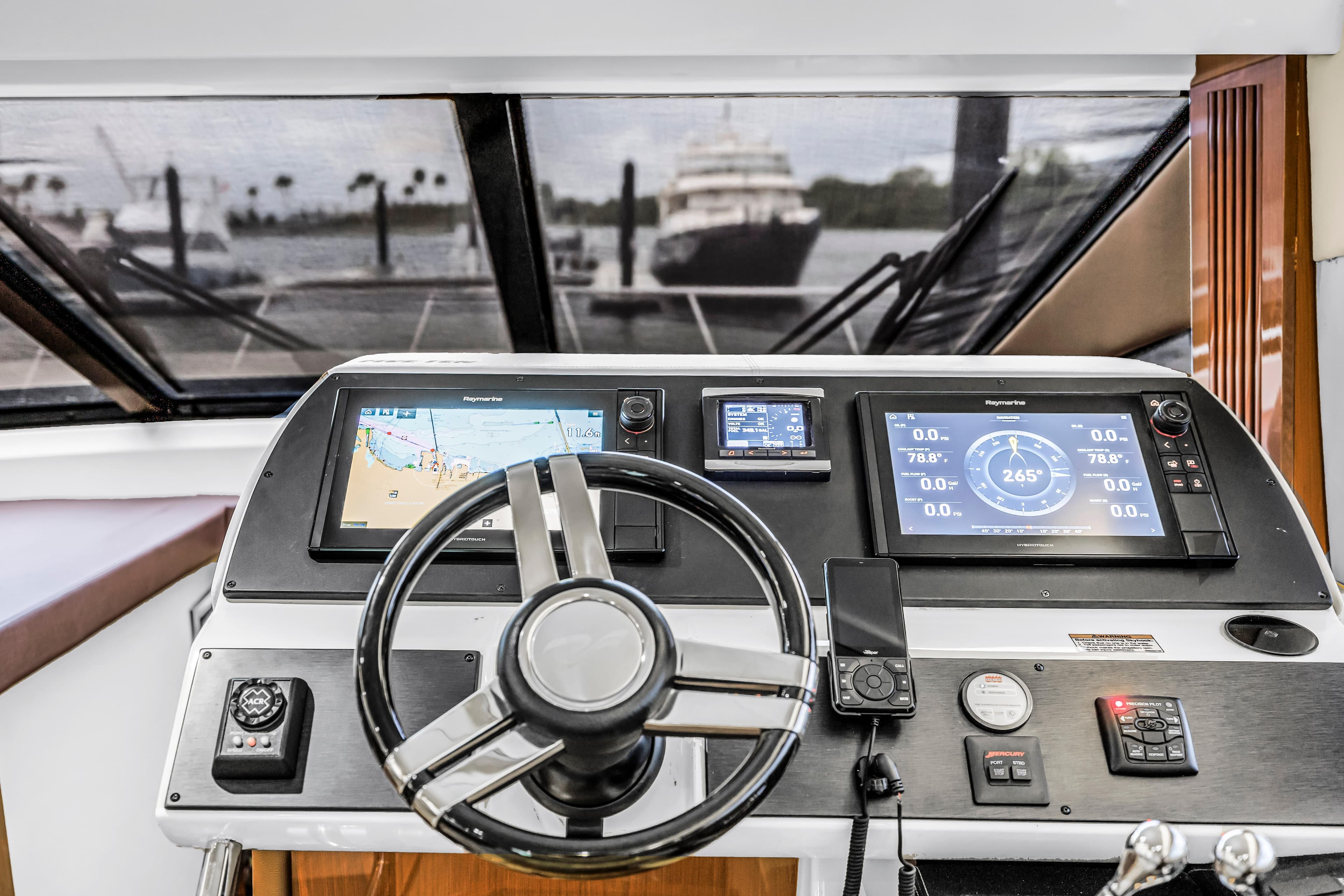 Helm of 2016 Sea Ray 510 Fly yacht with navigation displays and steering wheel.