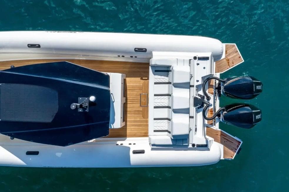 Aerial view of 2025 Technohull GTX boat with dual engines on blue water.