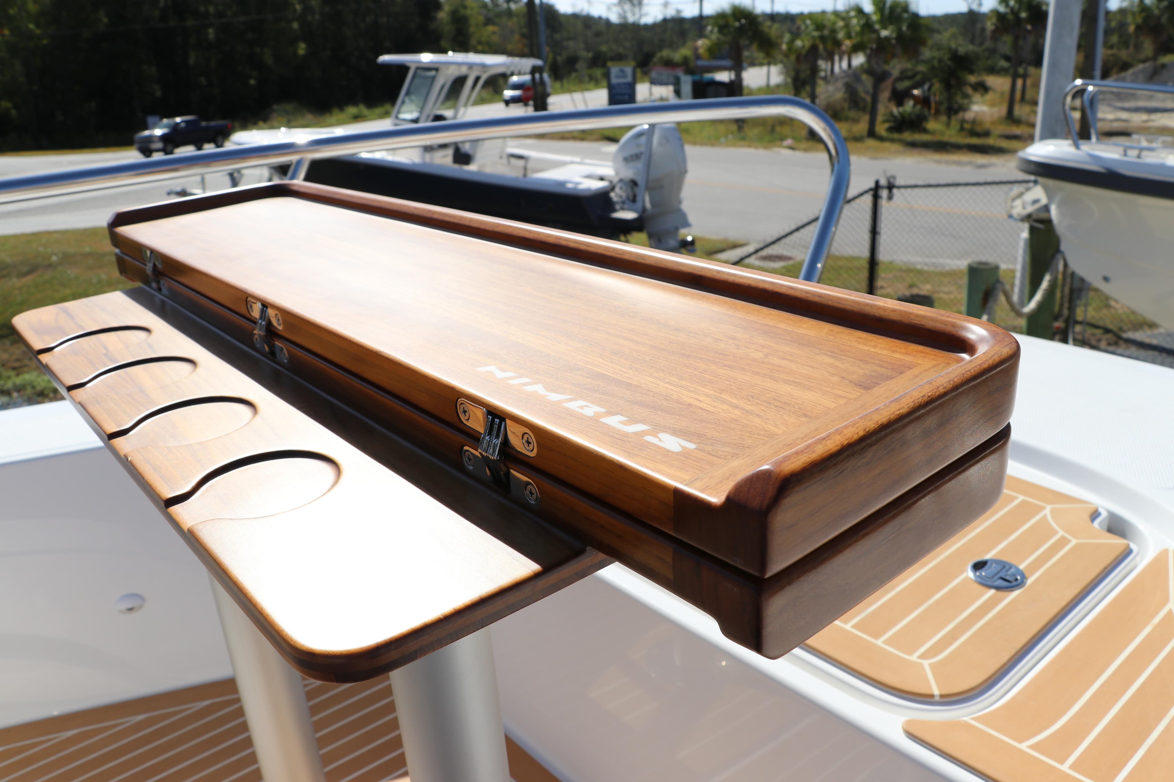 Wooden table on Nimbus T11 boat, 2025 model, featuring cup holders and sleek design.