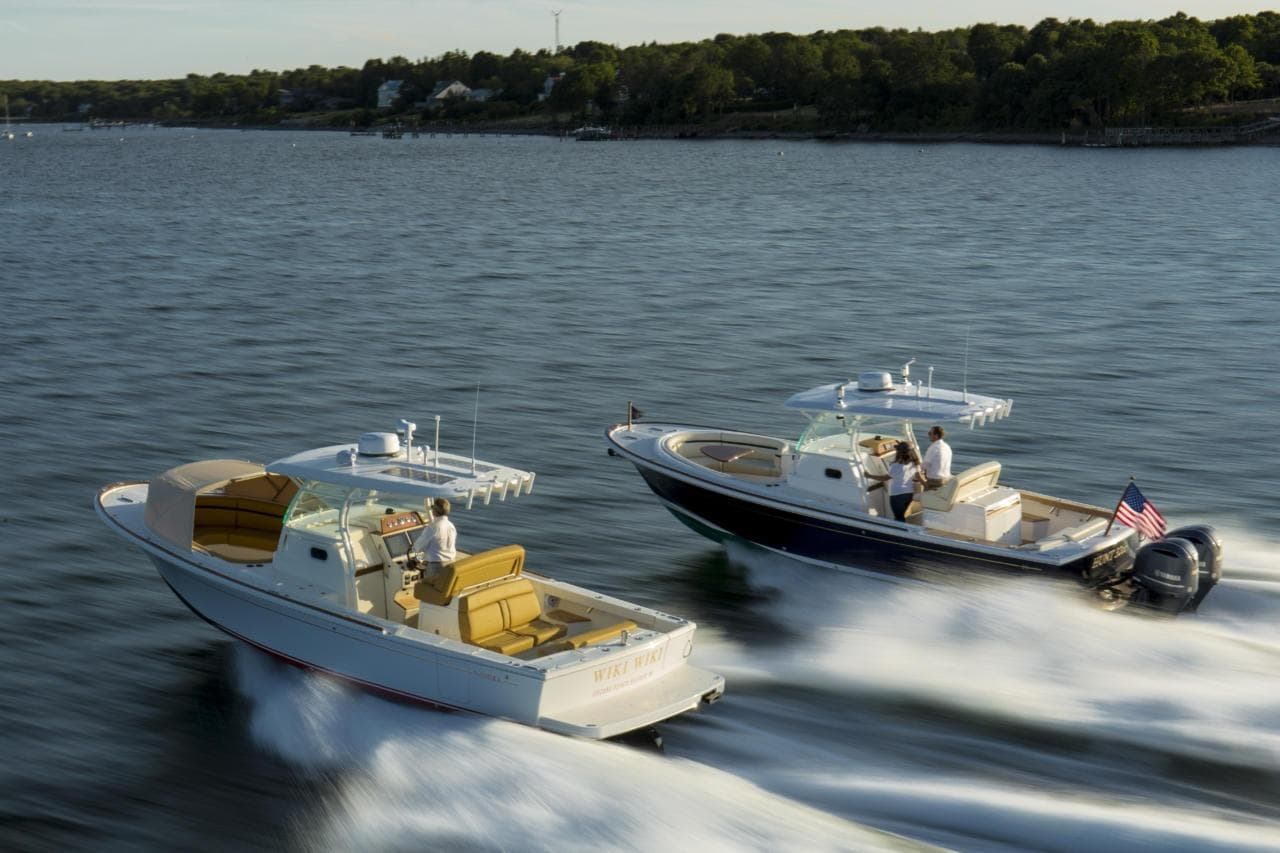 Two 2016 Hunt Yachts 32 Center Console boats cruising on a serene lake.