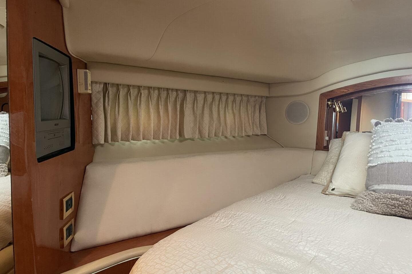 Interior cabin of 2000 Sea Ray 400 Sedan Bridge with bed and TV.
