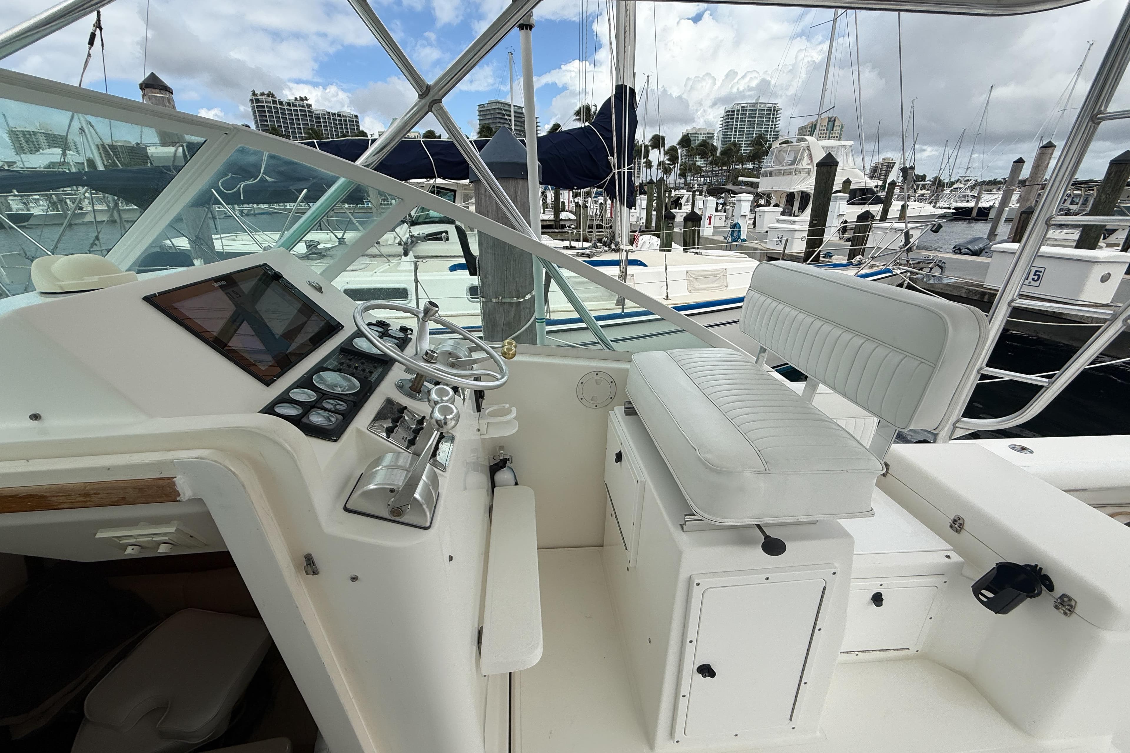 1998 Cabo 31 Express boat helm with white seating and marina view.