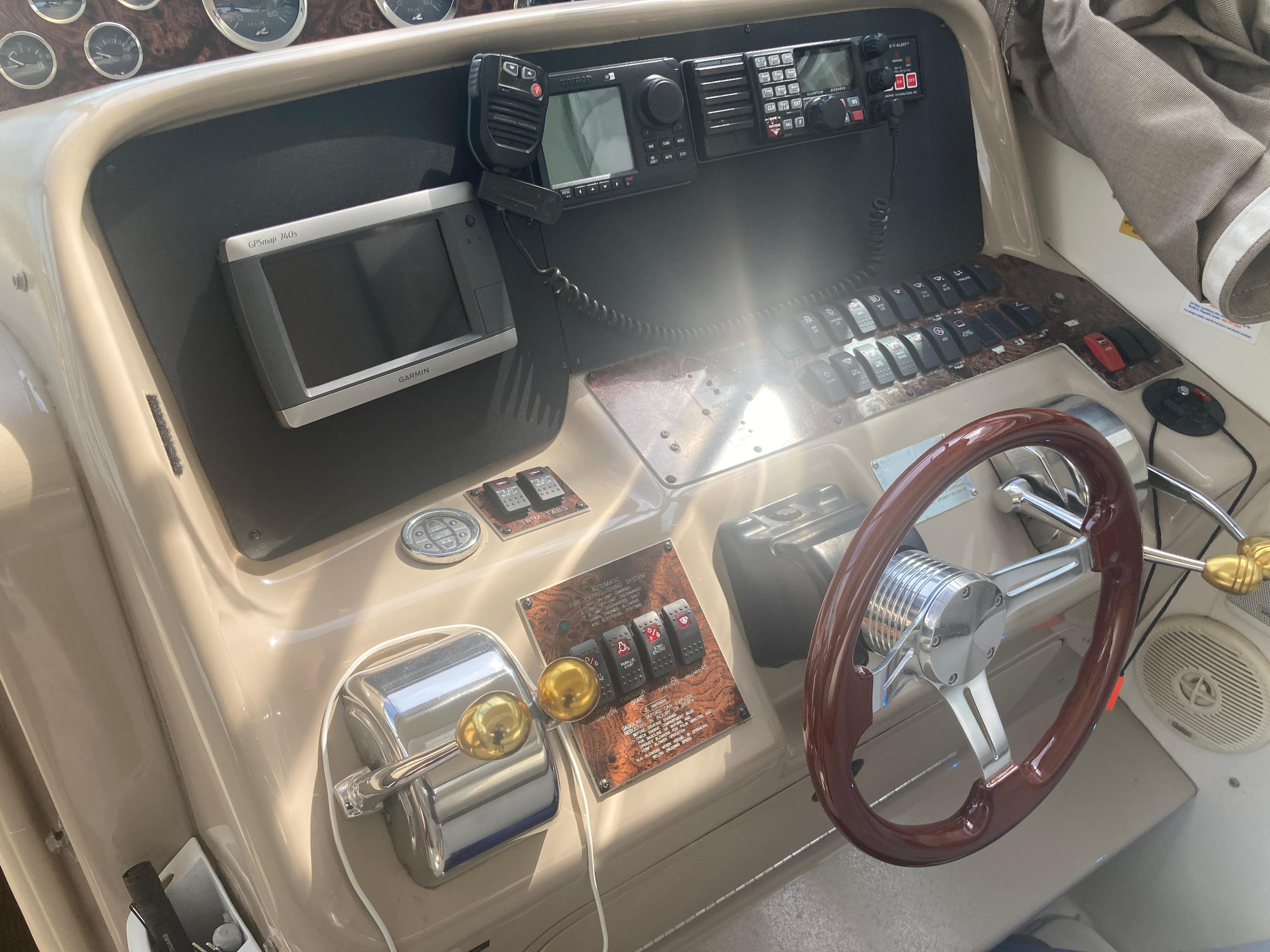 1999 Sea Ray 330 Express Cruiser helm with steering wheel and navigation controls.
