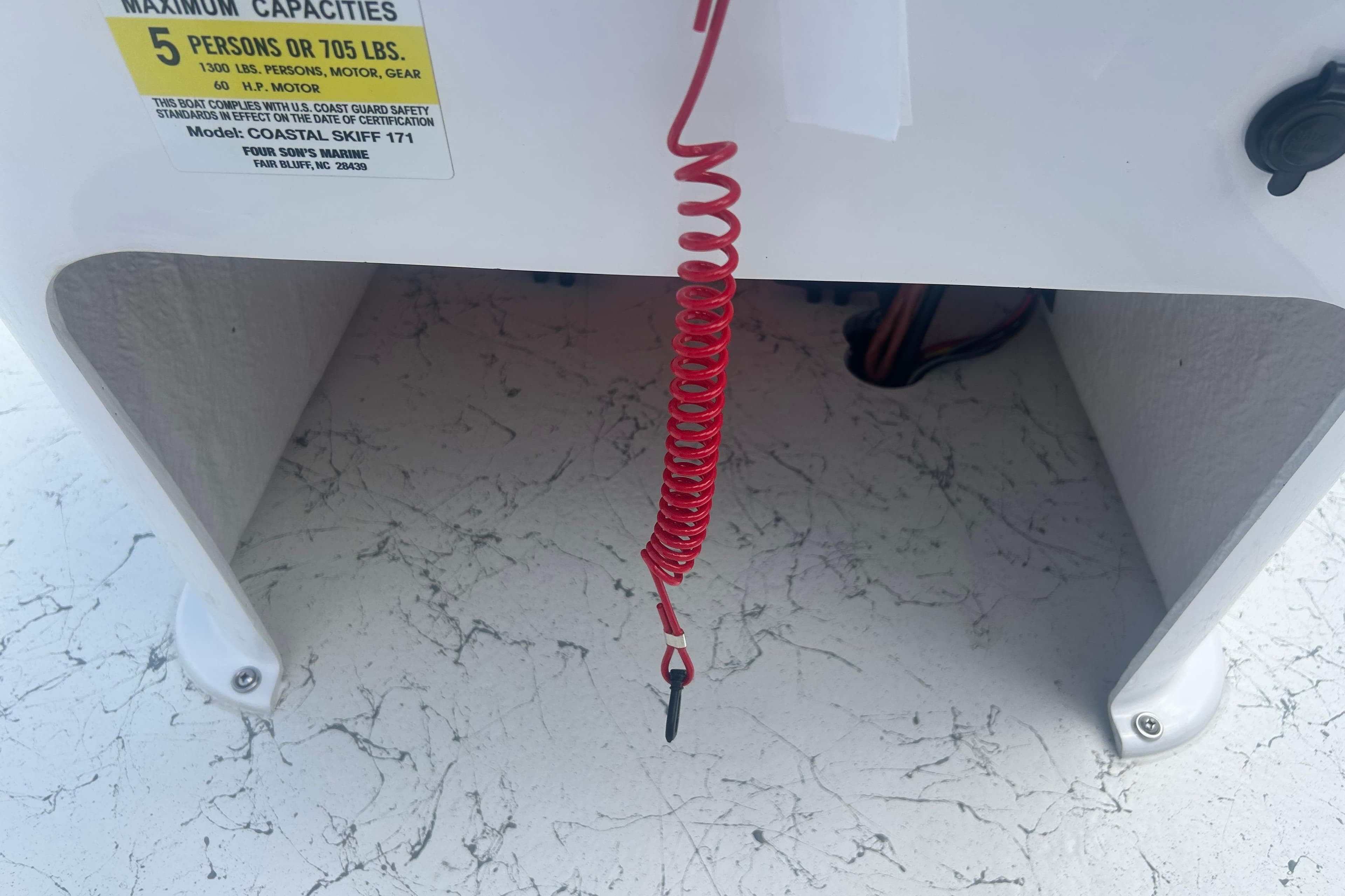 Red safety cord on a 2026 Coastal Skiff 171 boat with capacity label.