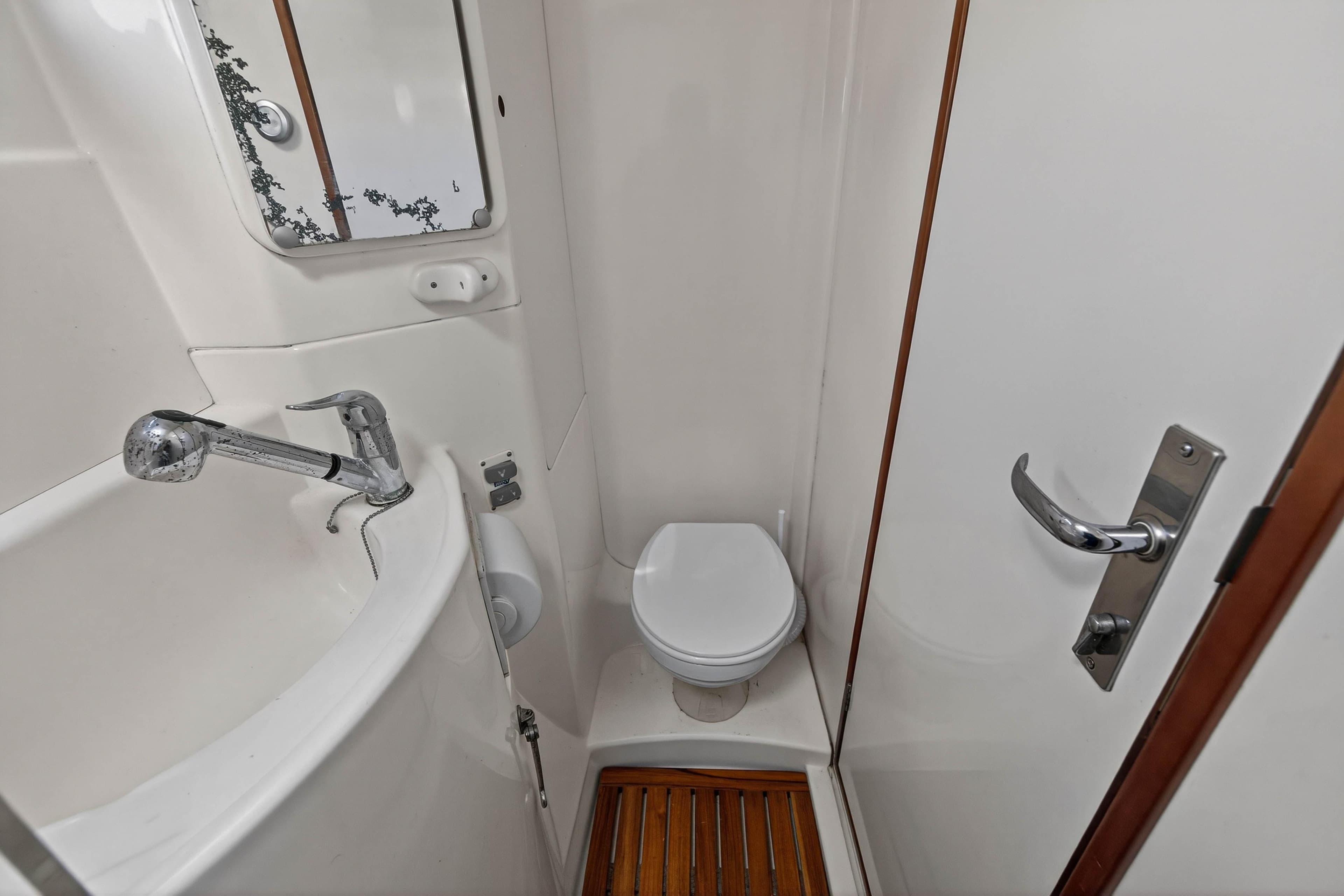 Compact bathroom in a 2012 Leopard 39 yacht, featuring a toilet, sink, and mirror.