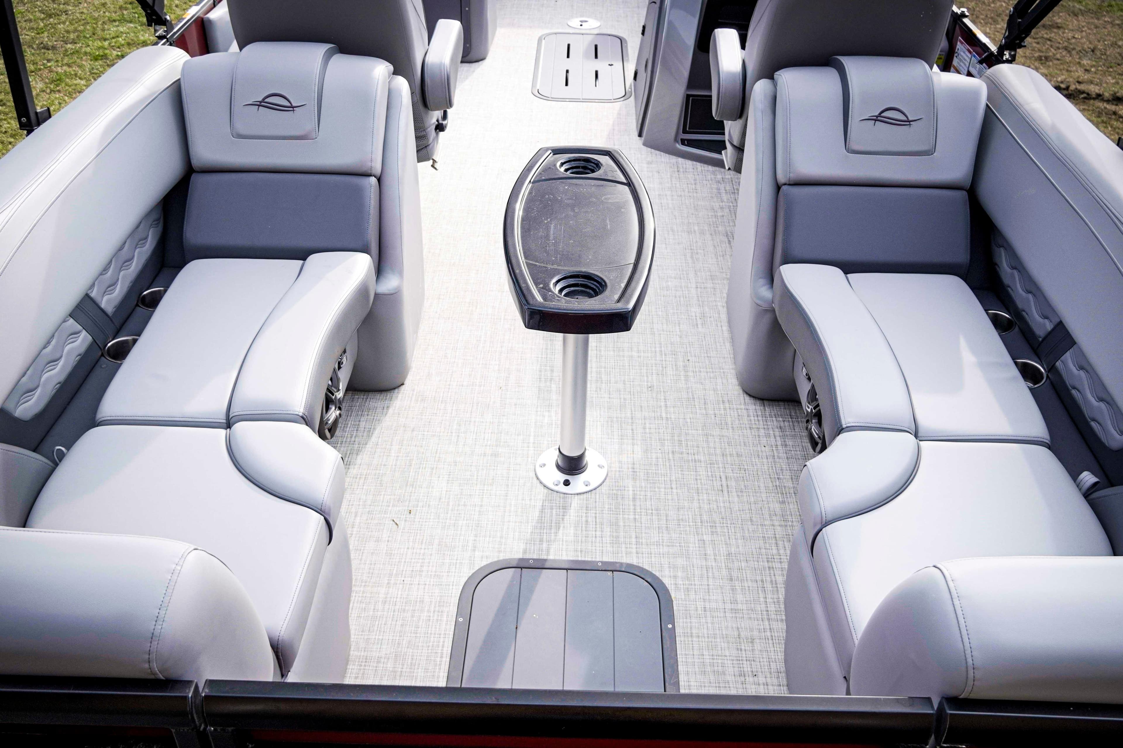 Luxurious seating area on 2025 SunCatcher Fusion 322RC pontoon boat with central table.