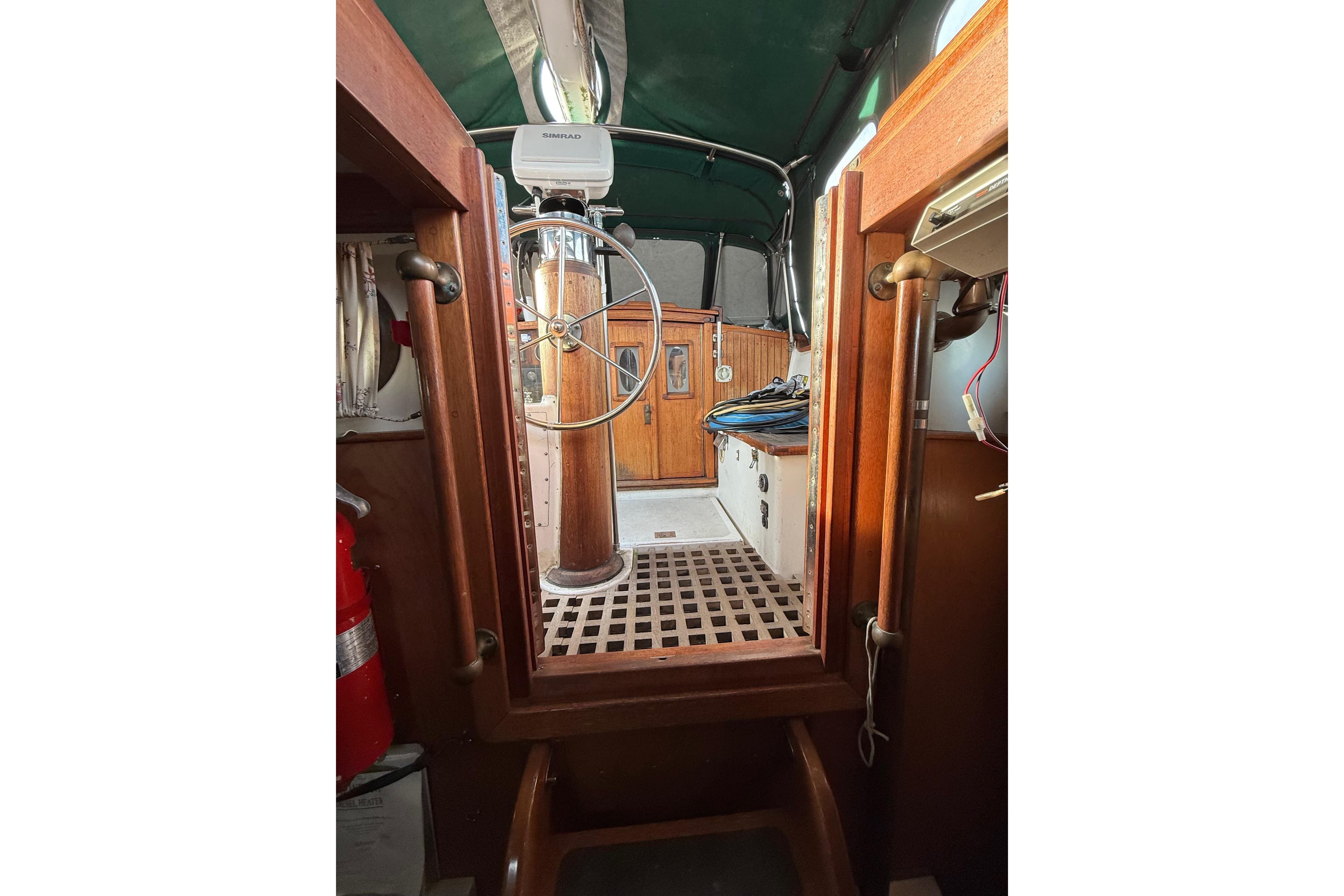 Interior view of a 1990 Custom 46 sailboat cockpit with wooden details and steering wheel.