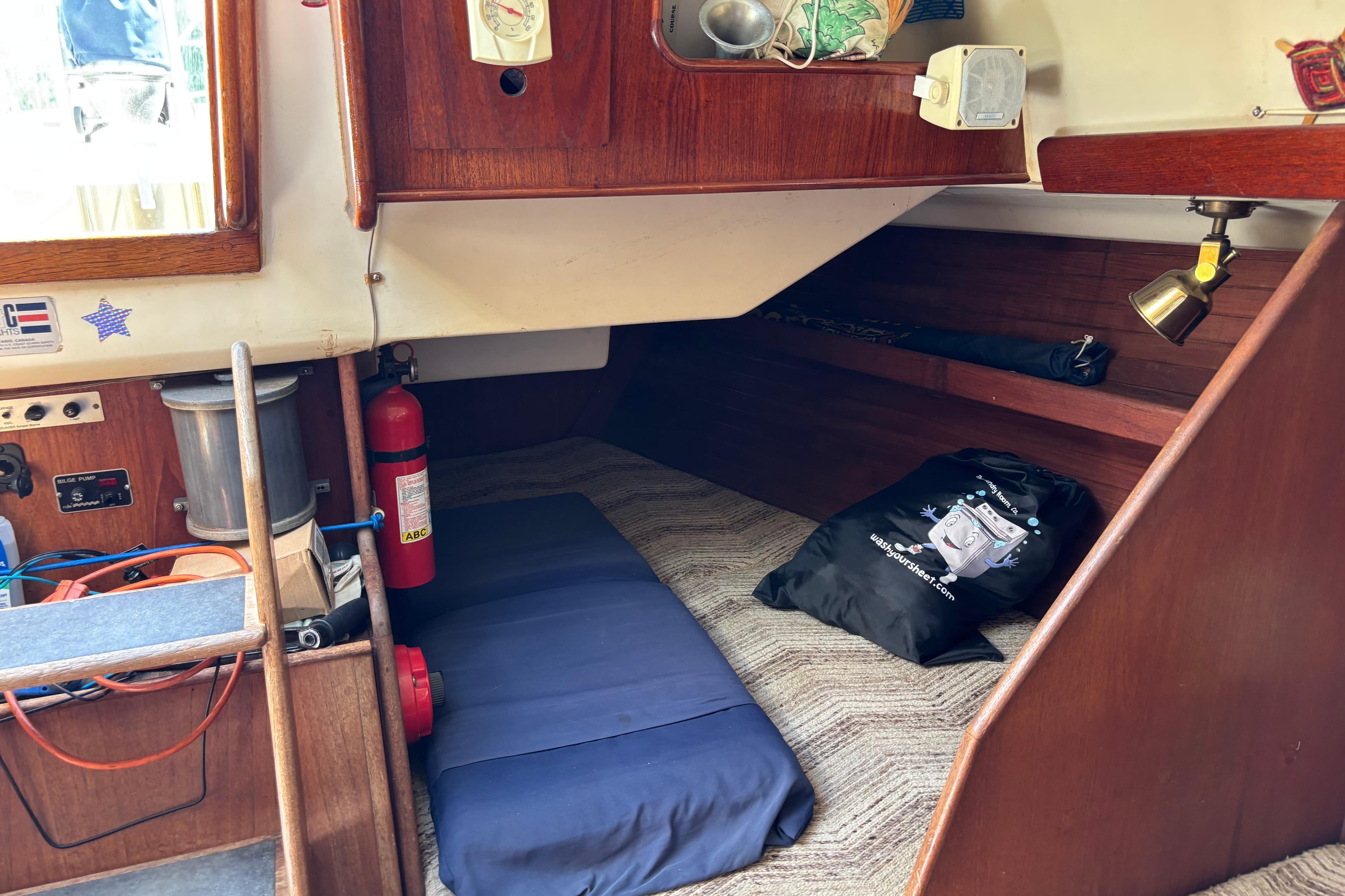 Cozy cabin interior of 1980 C&C 40-2 sailboat with fire extinguisher and storage.
