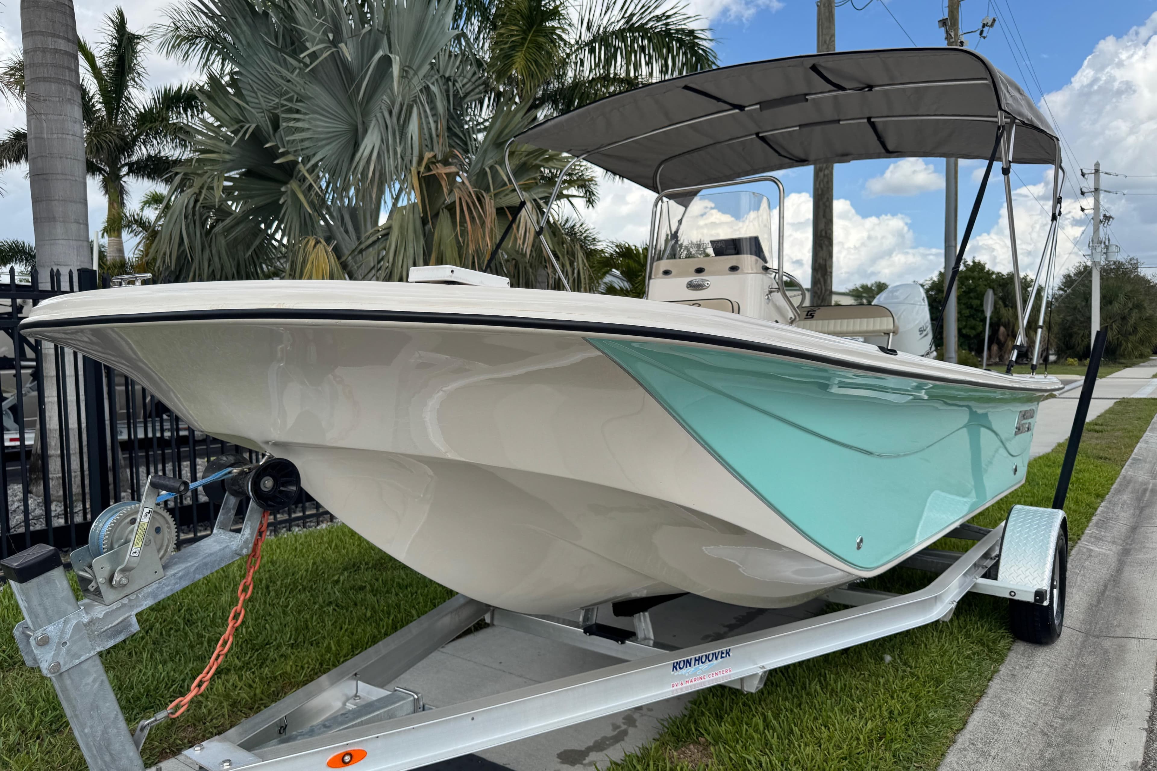 2022 Carolina Skiff 19 LS boat on trailer, parked near palm trees.