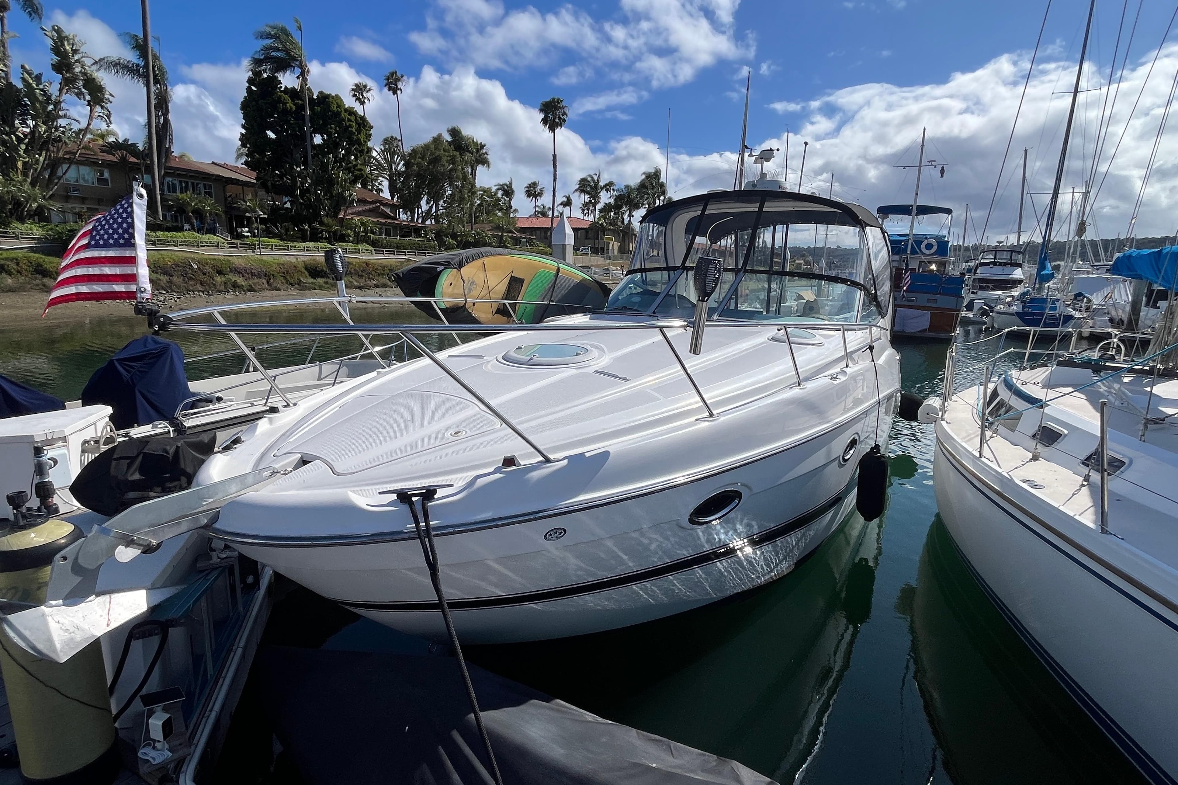2007 Maxum 3100 SE boat docked in a marina under a partly cloudy sky.