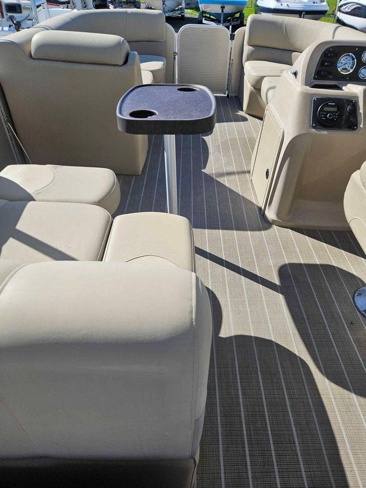 2019 Manitou 22 Aurora LE 220VP Tritoon Pontoon interior with beige seating and table.