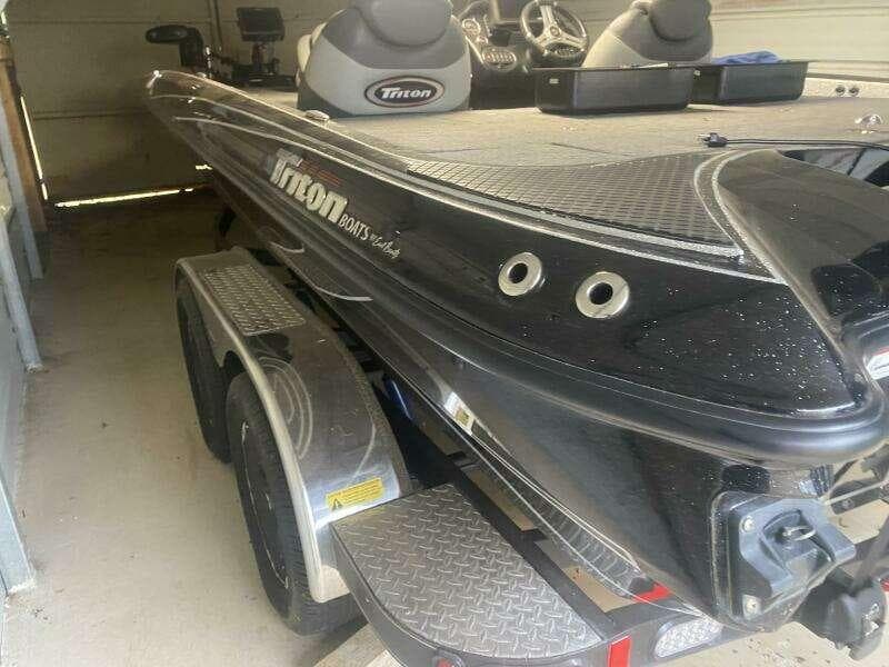 2016 Triton 20 TRX Elite boat on trailer in garage, black exterior.