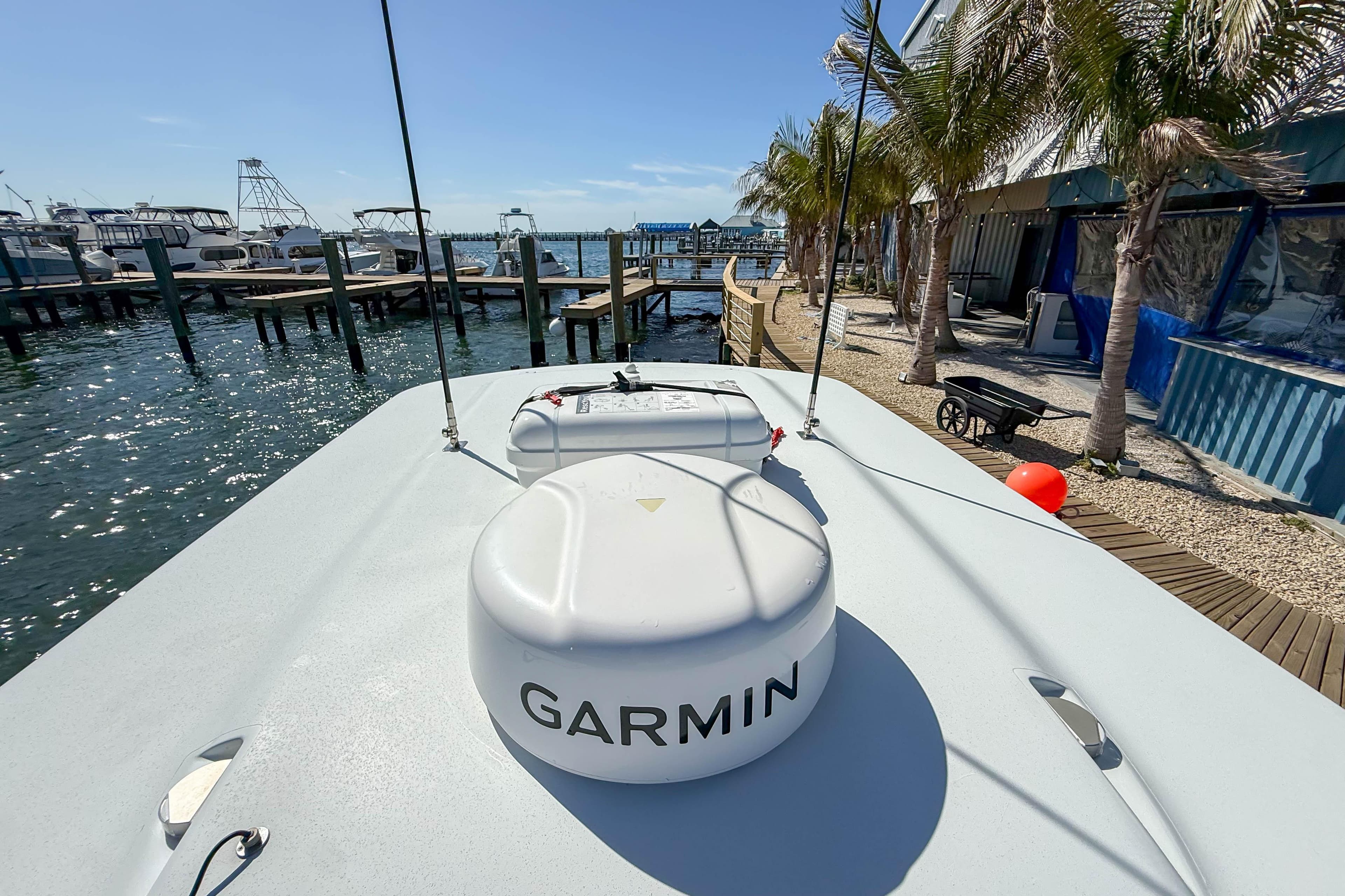2023 Costa Custom Boats 34 docked, featuring Garmin equipment, with marina and palm trees in background.
