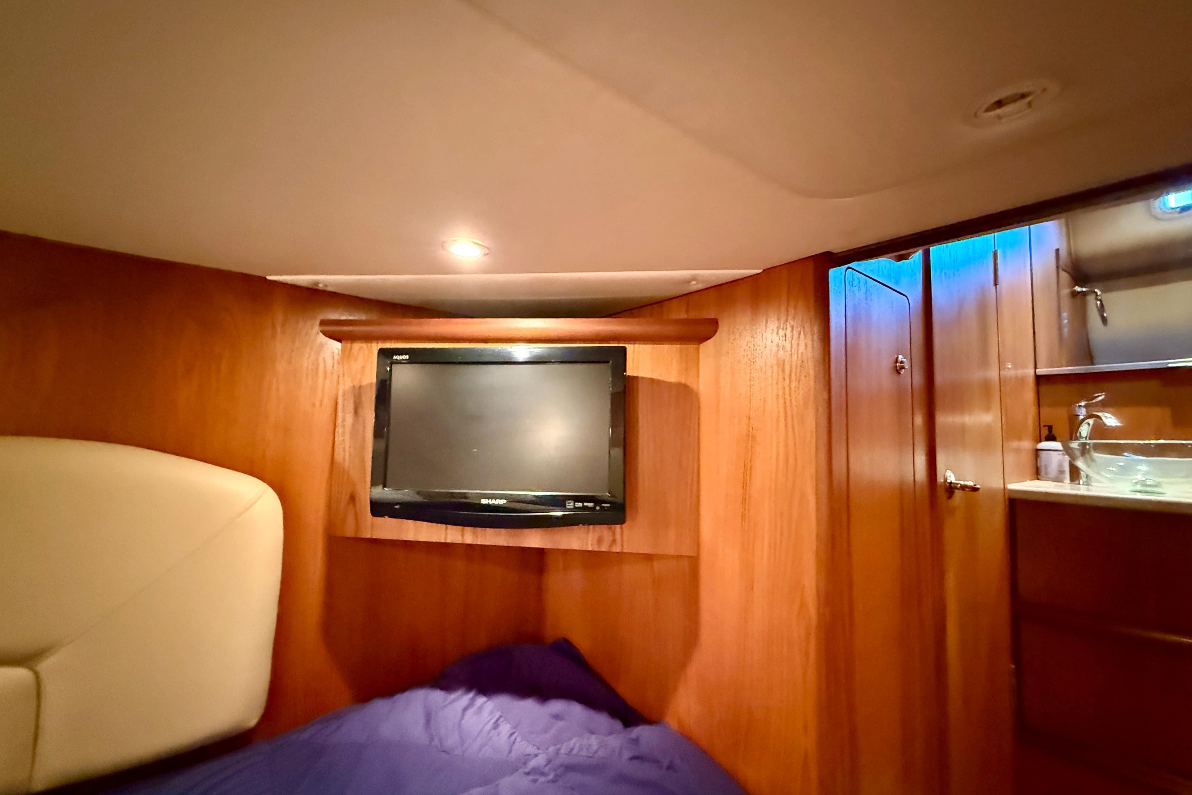Luxurious cabin interior of 2012 Tiara Yachts 4500 Sovran with TV and wooden finish.